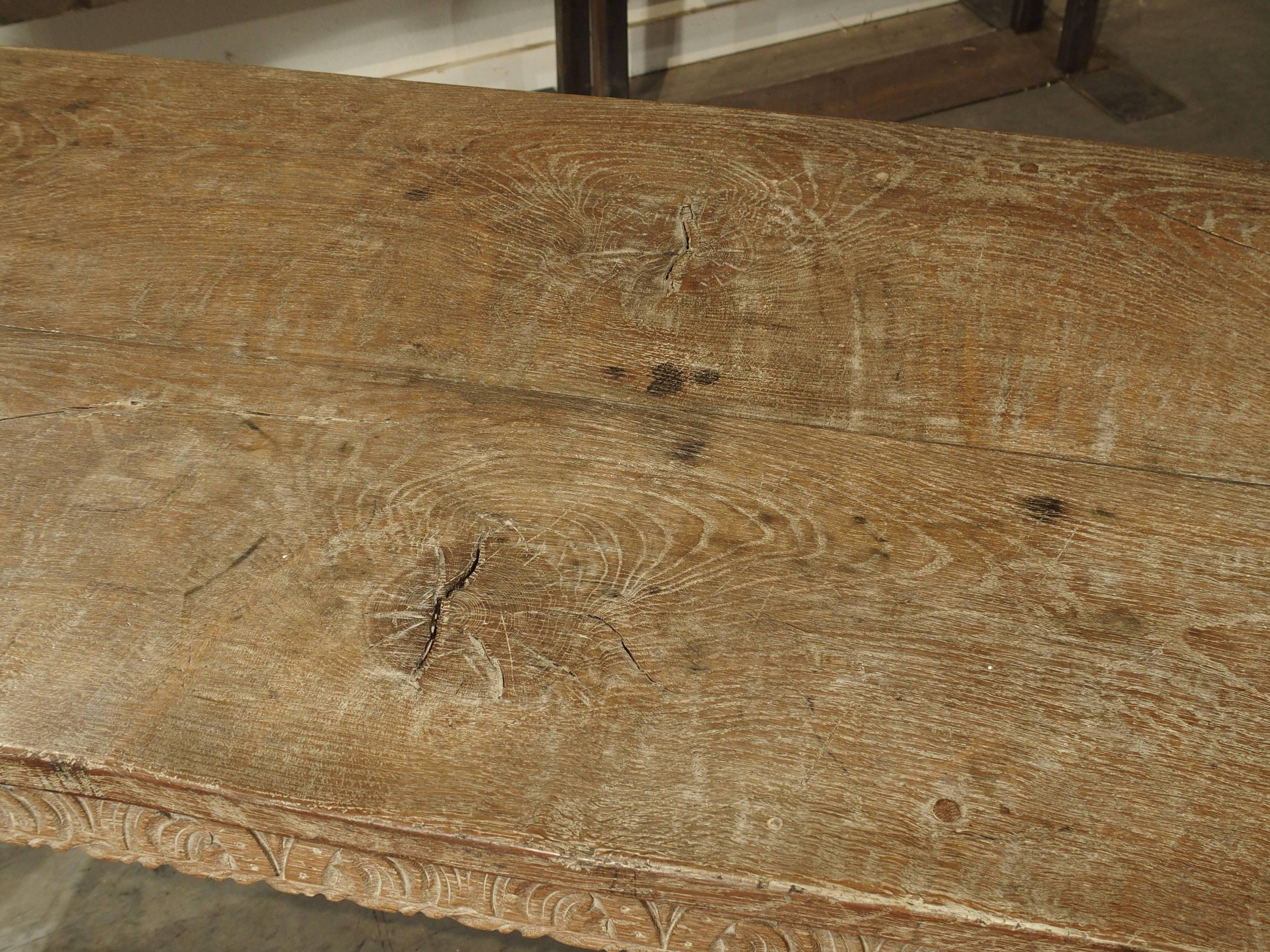 From England, this limed or whitewashed oak table dates to the early 1800s. The two- plank top has large graceful burls or knots at the centre of each plank as well as lovely graining throughout the rest of the wood. At the ends of the table are two