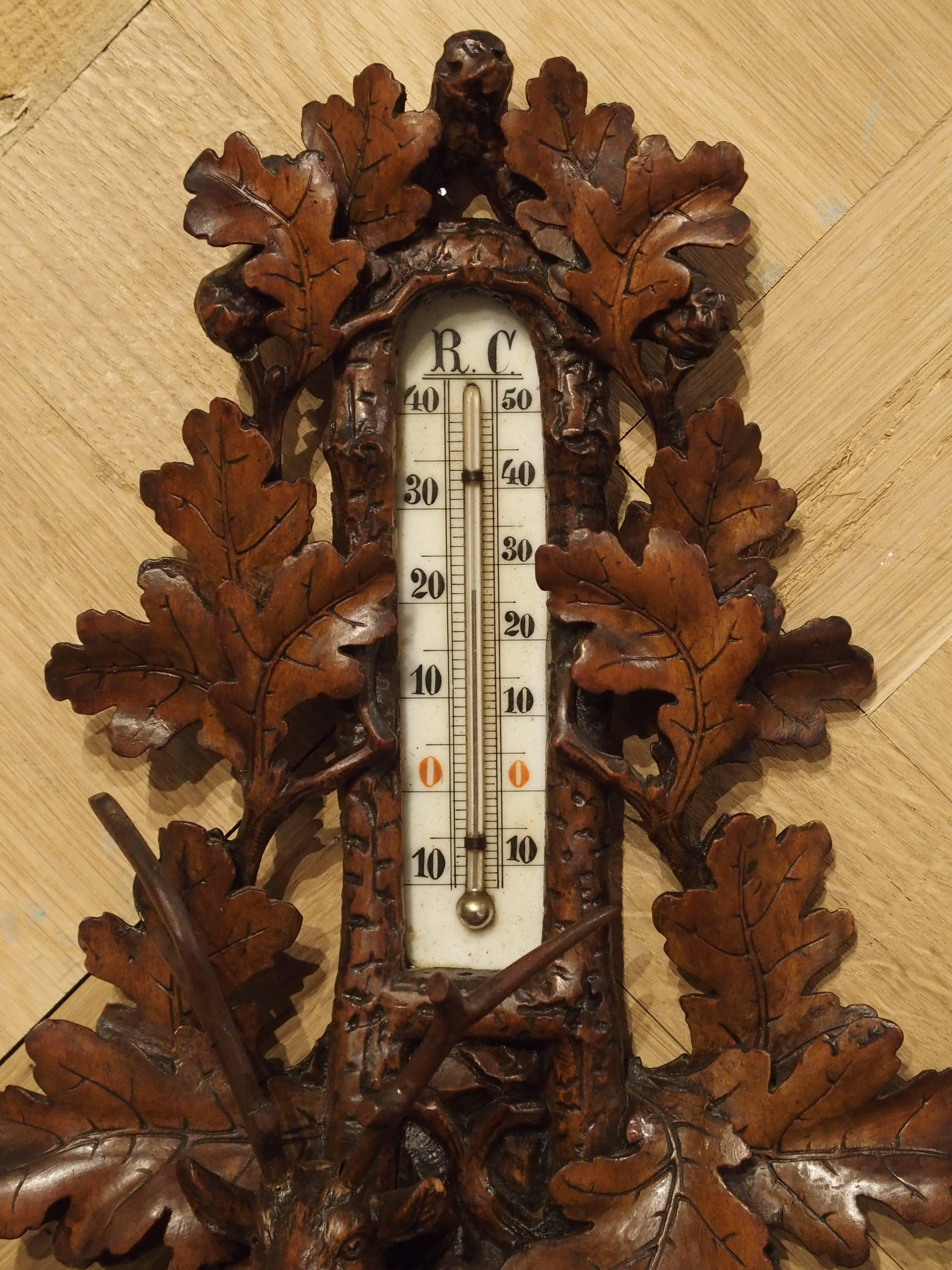 Completely hand-carved, this stunning, Black Forest wall hanging has a thermometer and barometer. It depicts a beautifully proportioned deer leaning against an embankment with its right leg. It is situated beneath the thermometer and above the