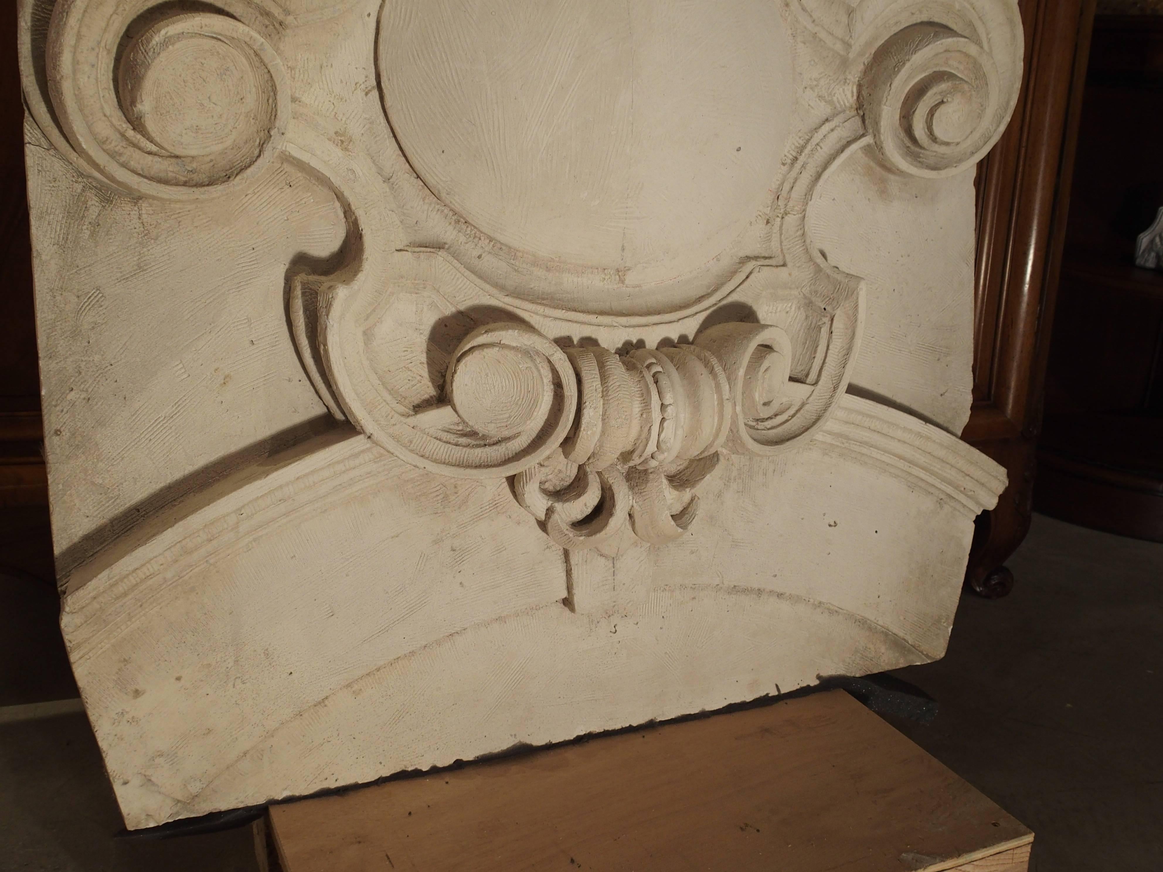 This beautifully hand carved plaster architectural from France has a cartouche as its main motif with scrolls to the side and bottom.  Resting upon the curved top are grapes, sunflowers and leaf motifs.  The cartouche rests upon the upper portion of