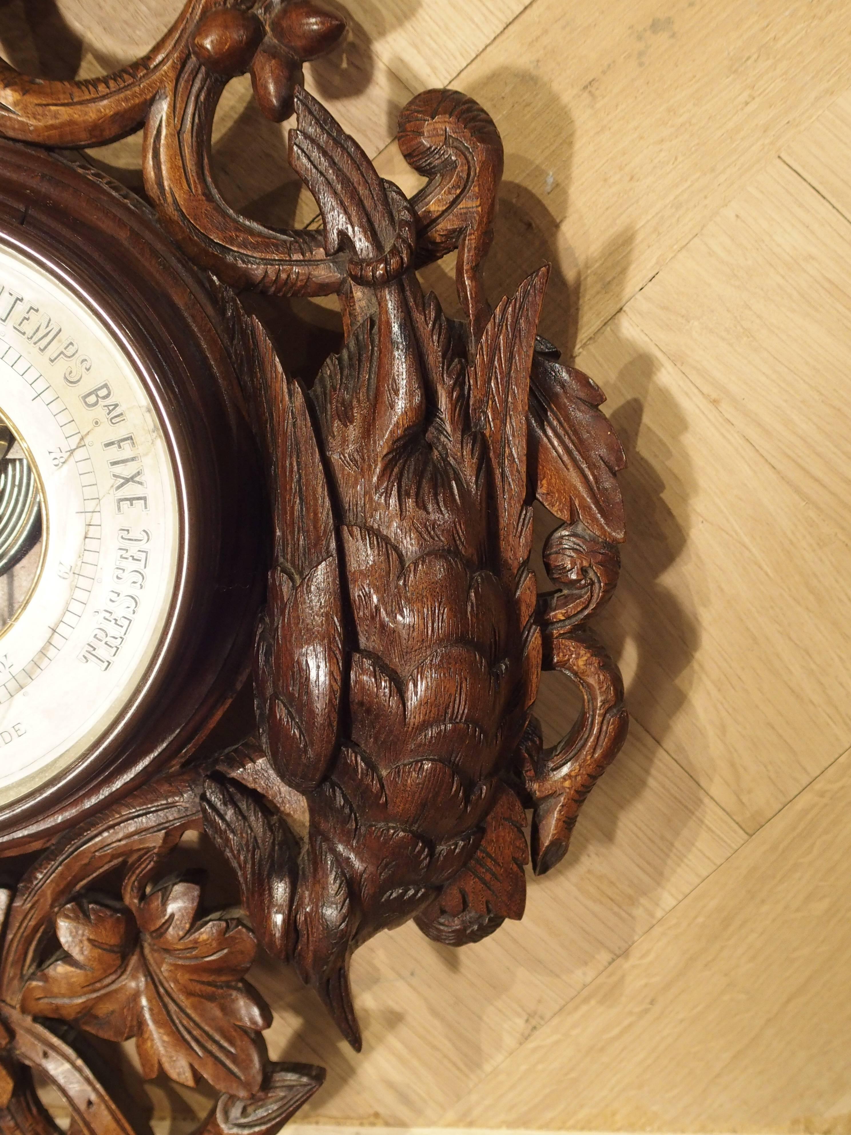 Found in France, this richly hand-carved, European oak, Black Forest carving dates to the late 1800s. There is a thermometer on the upper portion and a barometer on the lower portion. Above the thermometer, at the very top is an oak leaf, with a