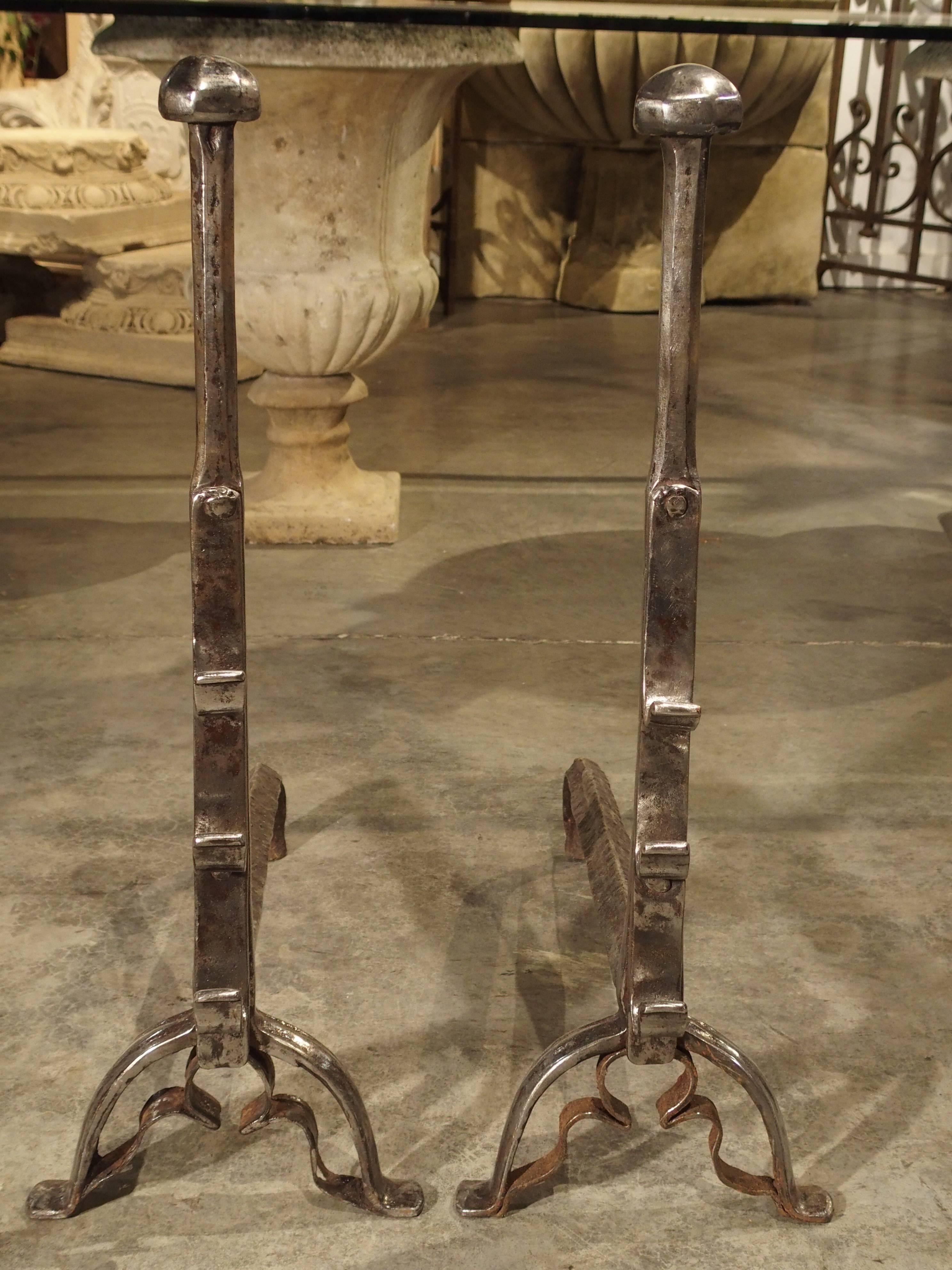 These artistically hand-wrought and hammered, 17th century andirons can be used in any style of design because of their elegantly simplicity. They have recently been lightly brushed and waxed with a clear paste wax, which gives them a beautiful