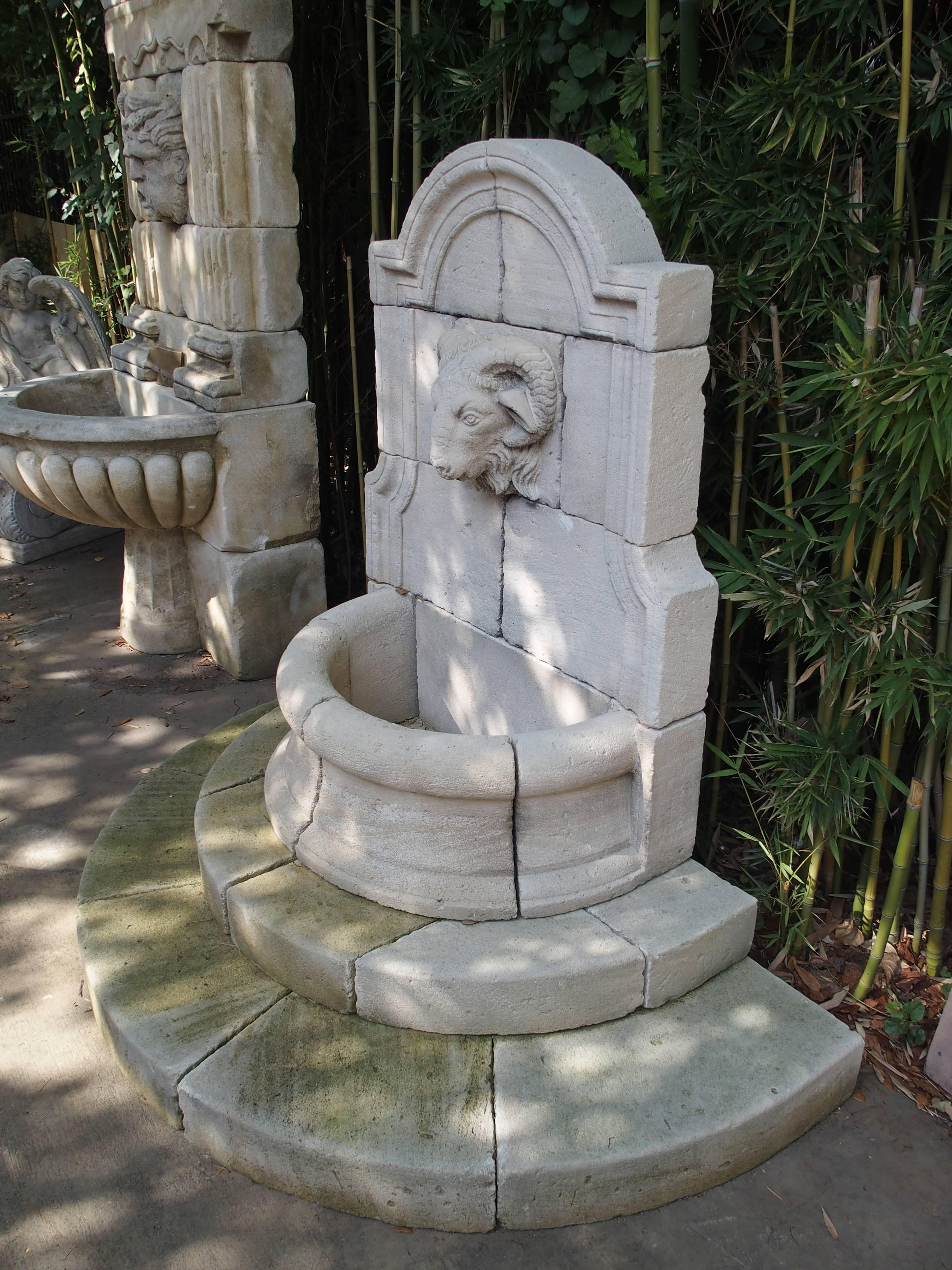 From France, this demilune, carved limestone wall fountain with a ram’s head spout makes a very elegant statement. There are demilune shapes throughout the entire fountain with no other motifs except the fountain spout. It has an arched top with 45-