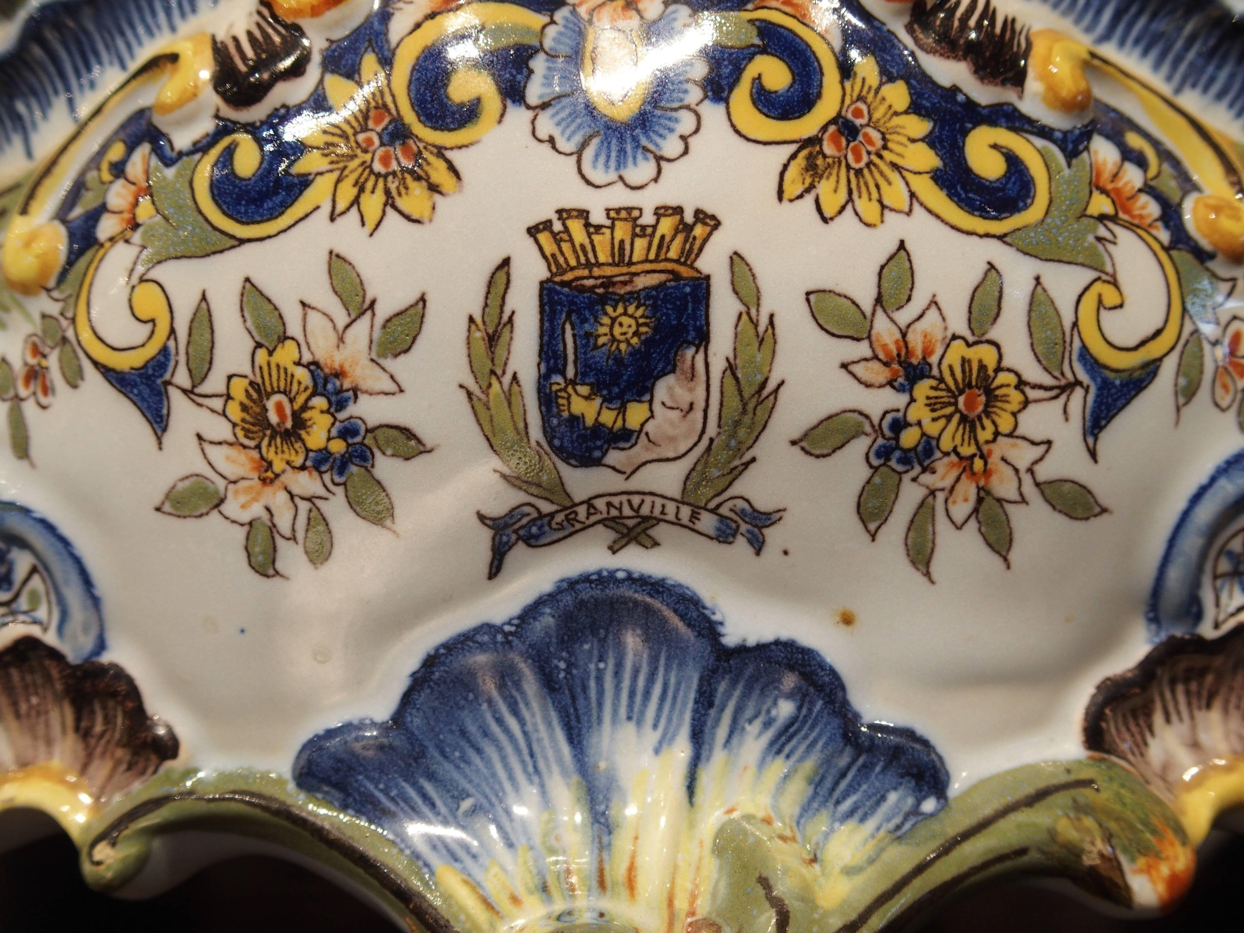 Dating to the early 1900s, this French Faience (tin glazed earthenware) jardinière has the coat of arms of Granville within a cartouche on the front. Granville is town along the coast of Normandy which produced faience decorative objects since the