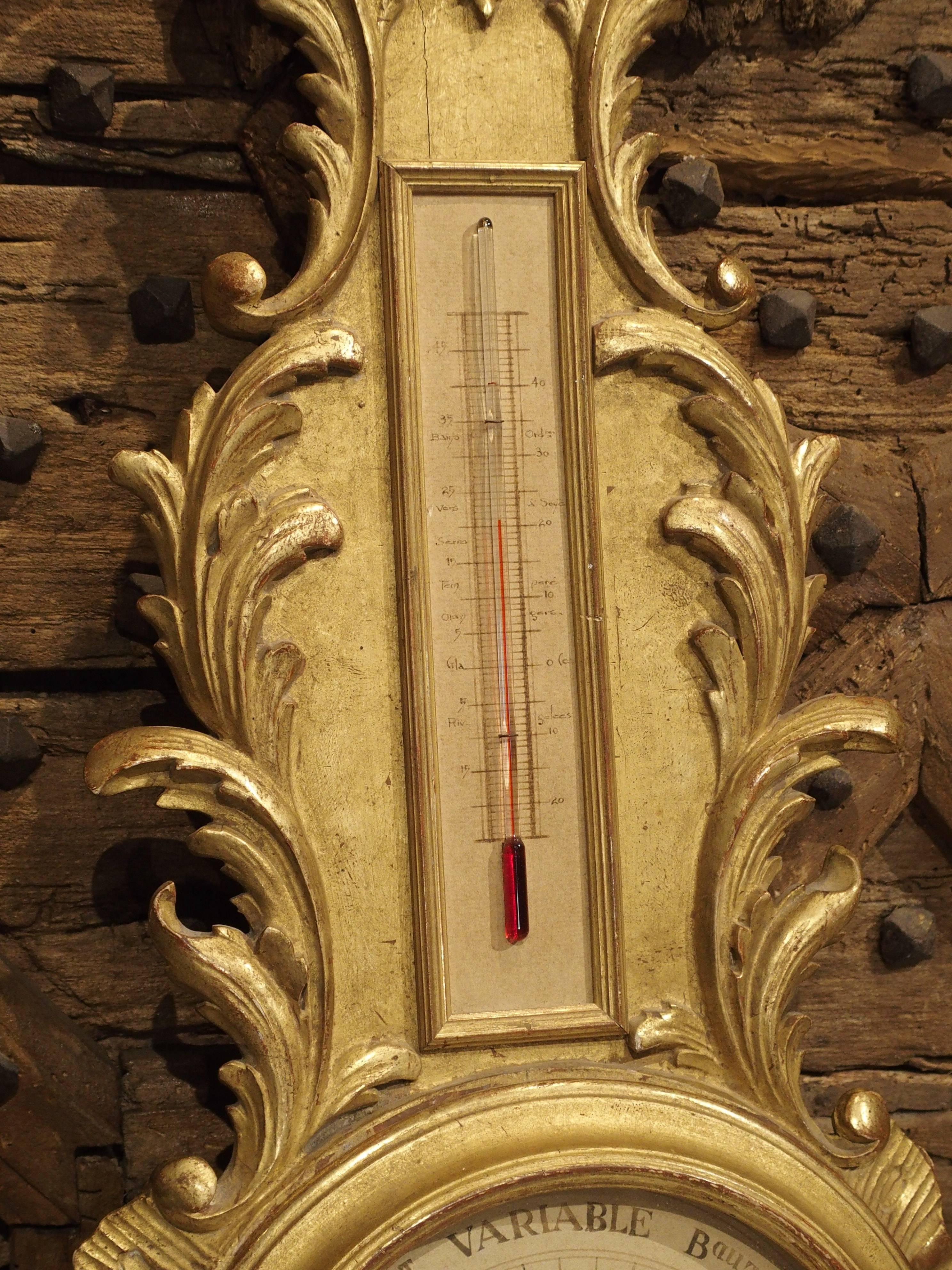 This elegant French, dual barometer or temperature has a beautiful giltwood surround with motifs in the Regence style. There are stylized shells and acanthus leaves, and the giltwood has a mixed matte and shiny finish atop red bole. There is an
