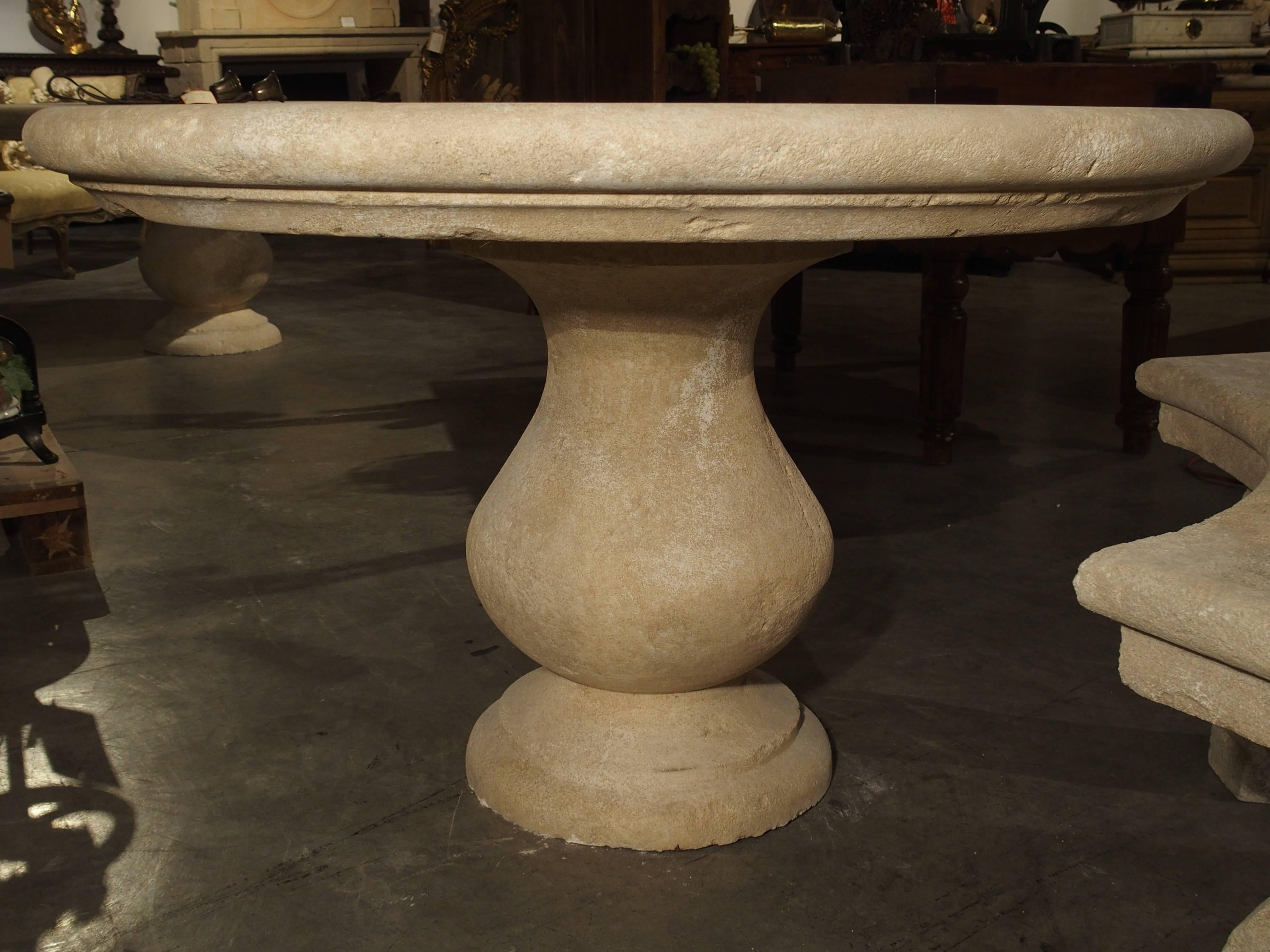 This versatile, hand carved, round stone table from France can be used outside as well as inside. It is made of French estaillade limestone, which has been used for centuries in the creation of outdoor pieces. The rounded edge top sits on a large,