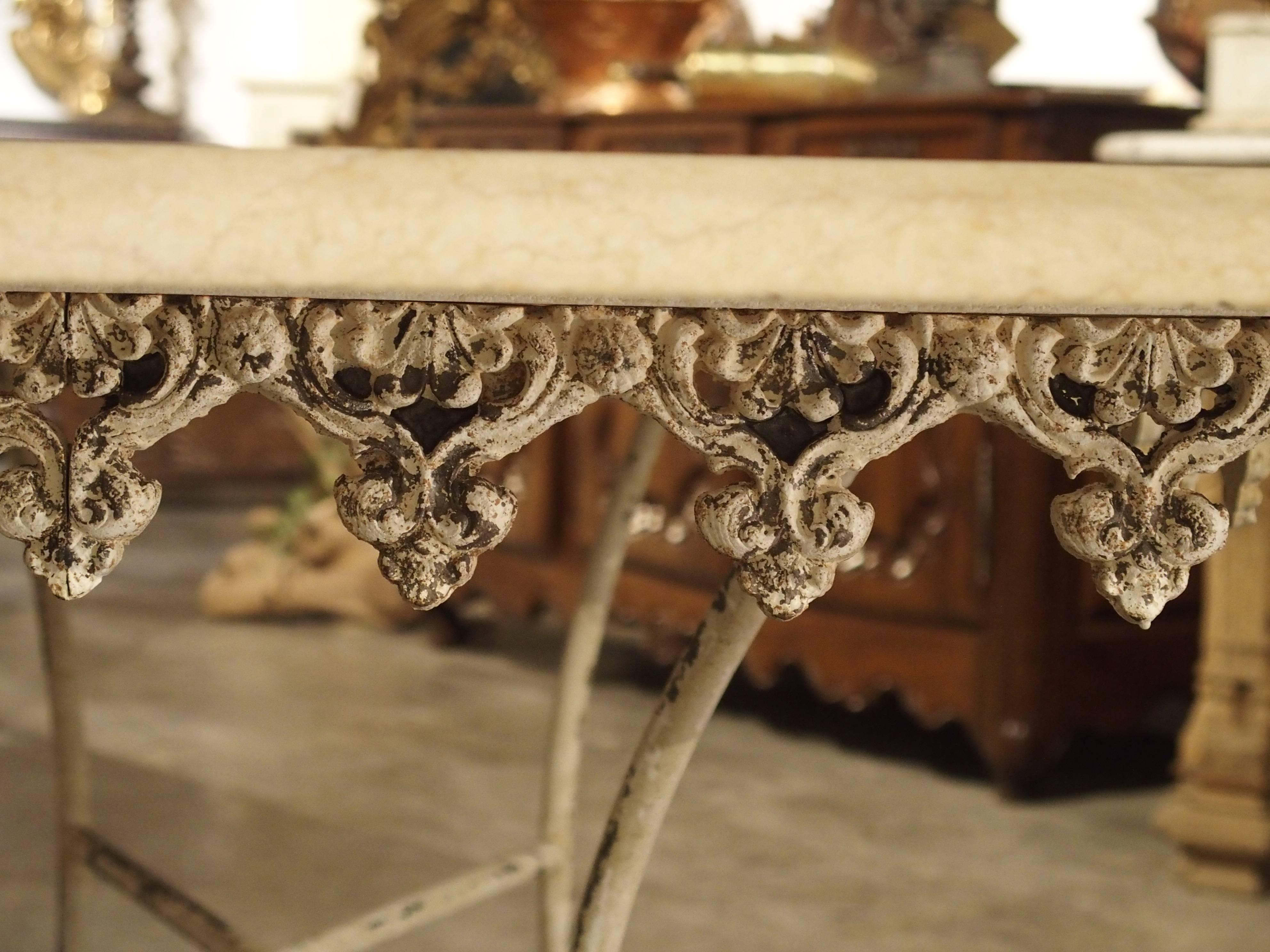 Cette belle table à plateau en marbre a une base en fonte avec un embout central en bronze.  Des tables comme celle-ci étaient utilisées dans les boucheries françaises pour présenter les morceaux de viande et autres aliments. Cependant, cette table