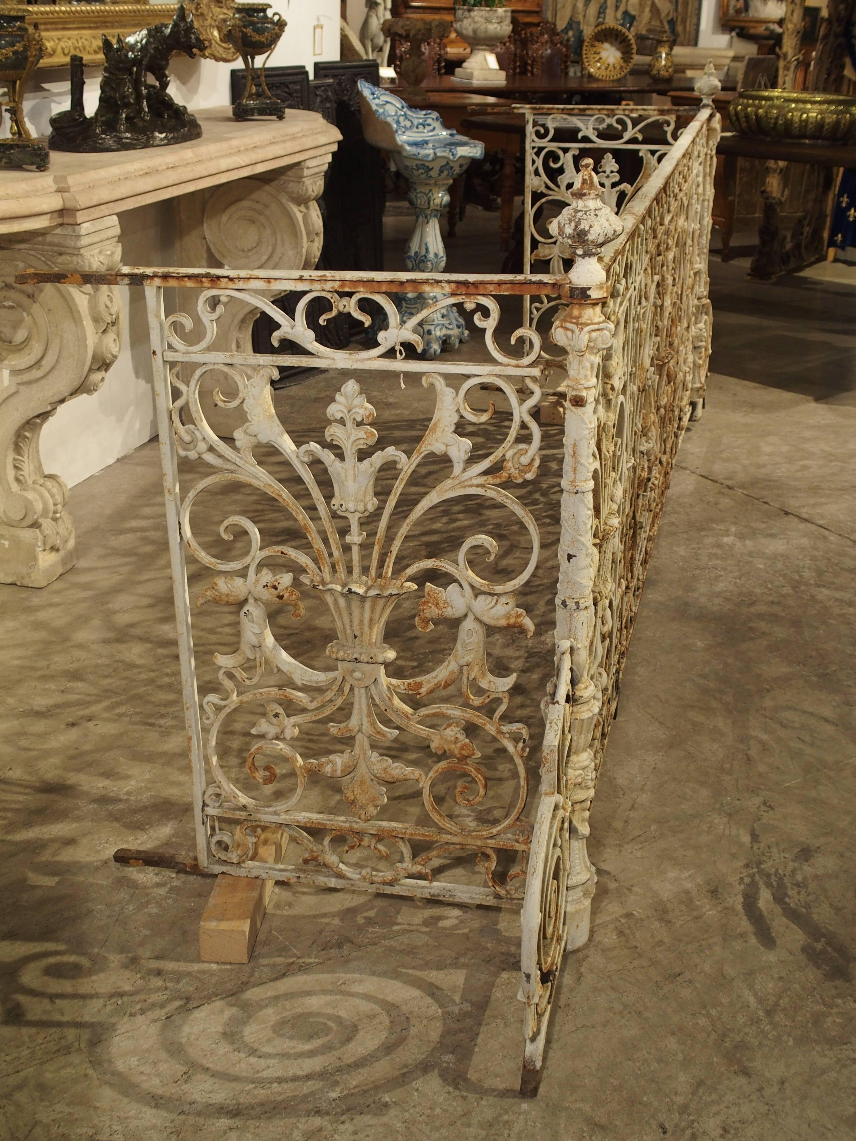 This is a stunning antique French balcony gate from the South of France. It was made in the mid to late 1800s, and its total length is over 11 feet! It would have been on a large and ornate building facade. The railing is made up of a series of