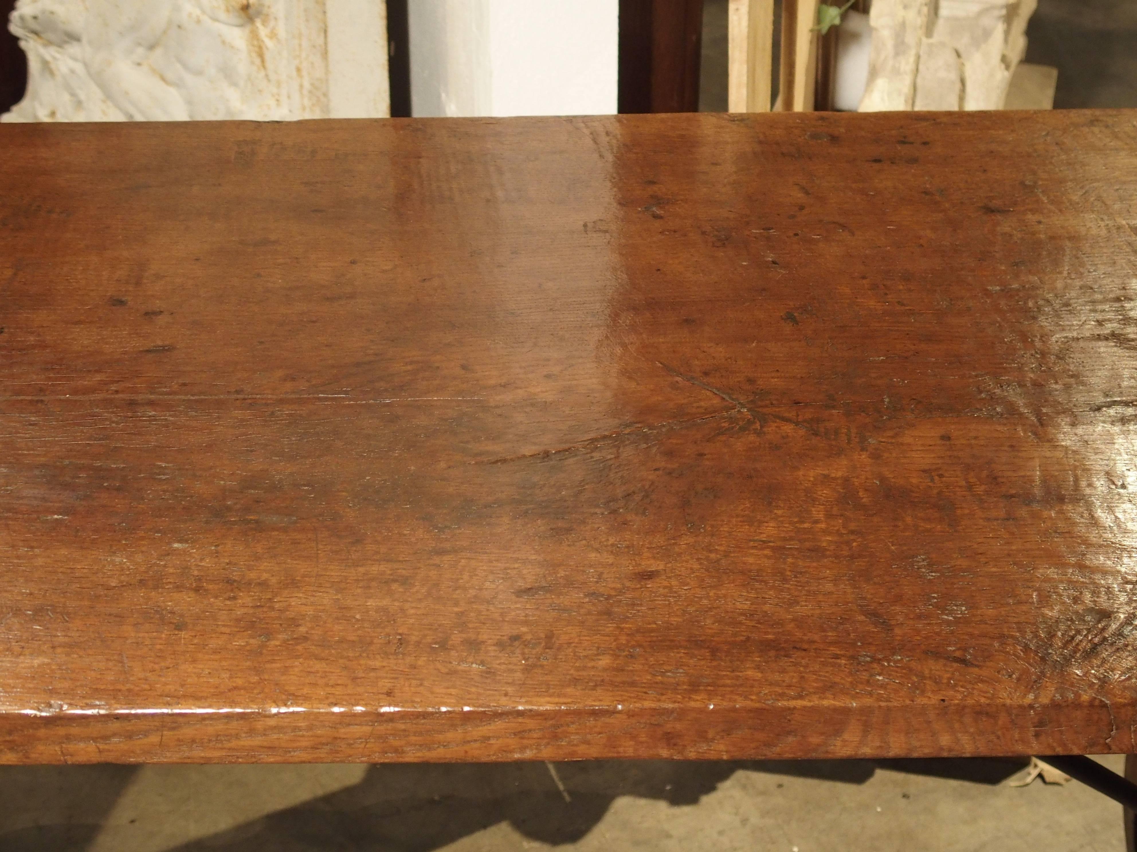 Dieser seltene Refektoriumstisch aus Nussbaumholz und Eiche aus dem 18. Jahrhundert in Spanien hat eine Platte aus einem einzigen Stück Holz. Der Überhang des Verdecks ermöglicht eine sehr bequeme Sitzgelegenheit an beiden Enden. Die Beine sind,
