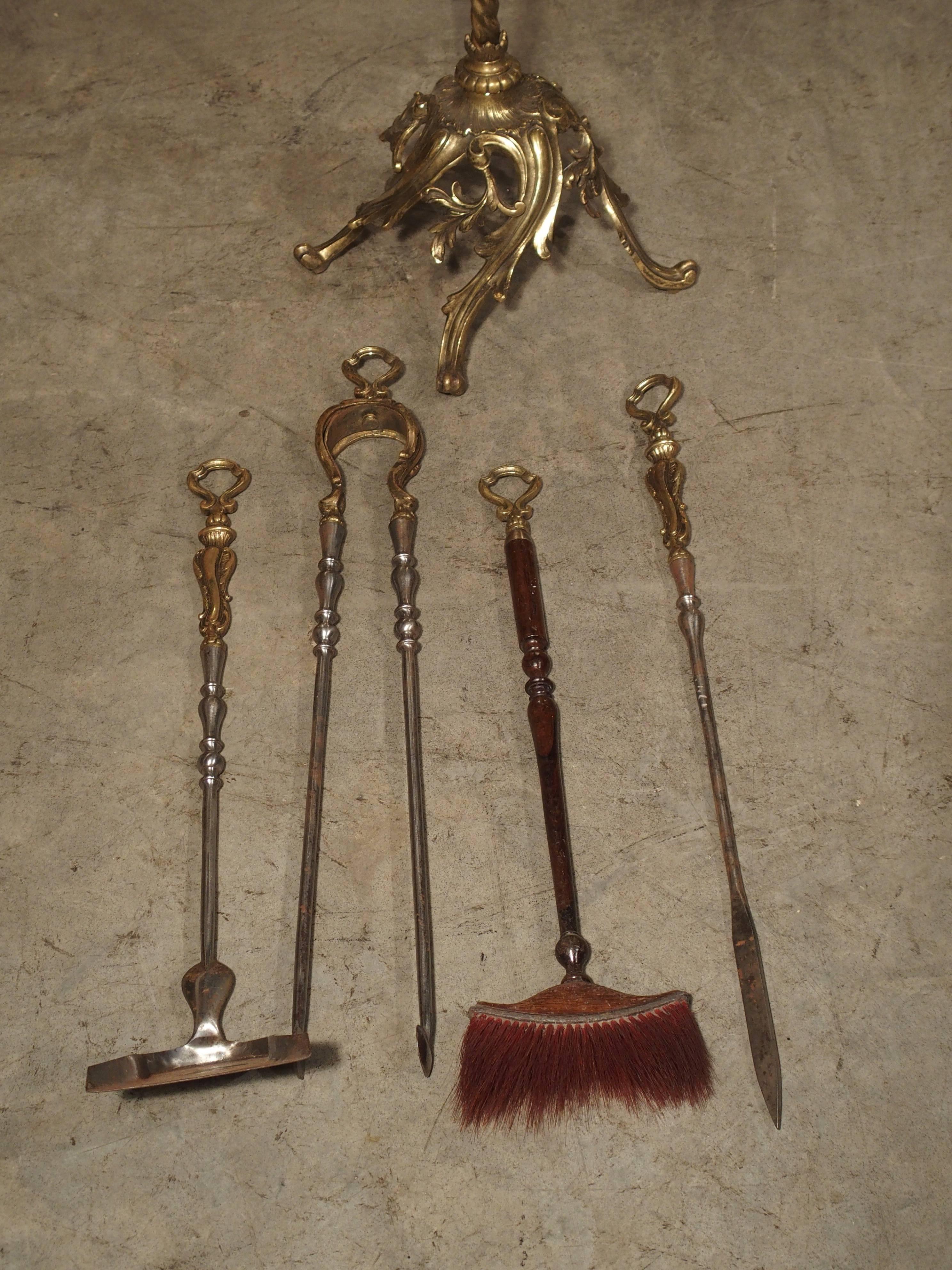 This complete set of French gilt bronze, wood and steel fireplace implements is from the 19th Century. The tops are all gilt bronze while the shafts are either wooden or steel. The bronze loops for hanging are the same ornate design on each tool. At
