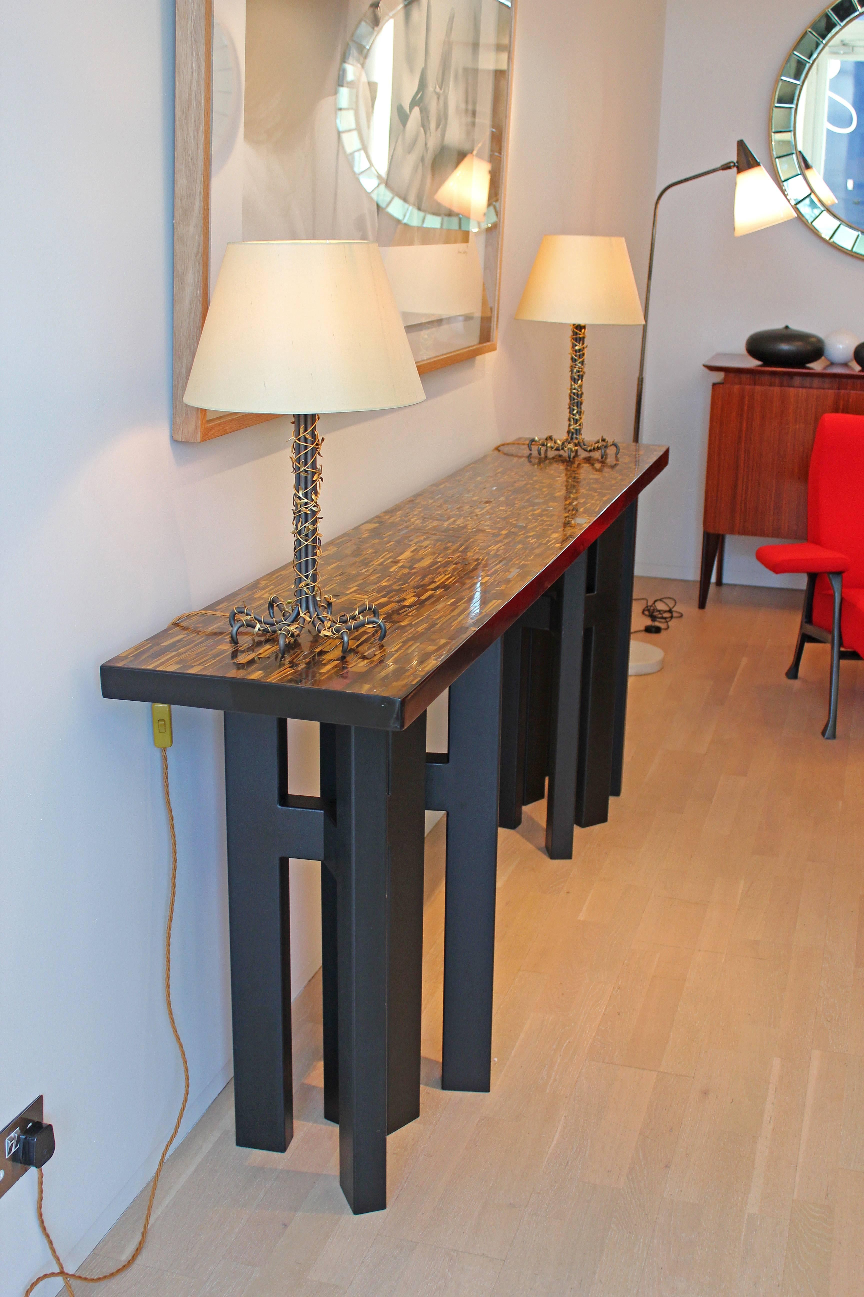 Rare long console table by Ado Chale. Resin top inset with tiger's eye and agate semi-precious stones on lacquered metal feet. Signed in gold and inset with a small ruby side of top. Vintage Ado Chale tables are rare to find especially in these