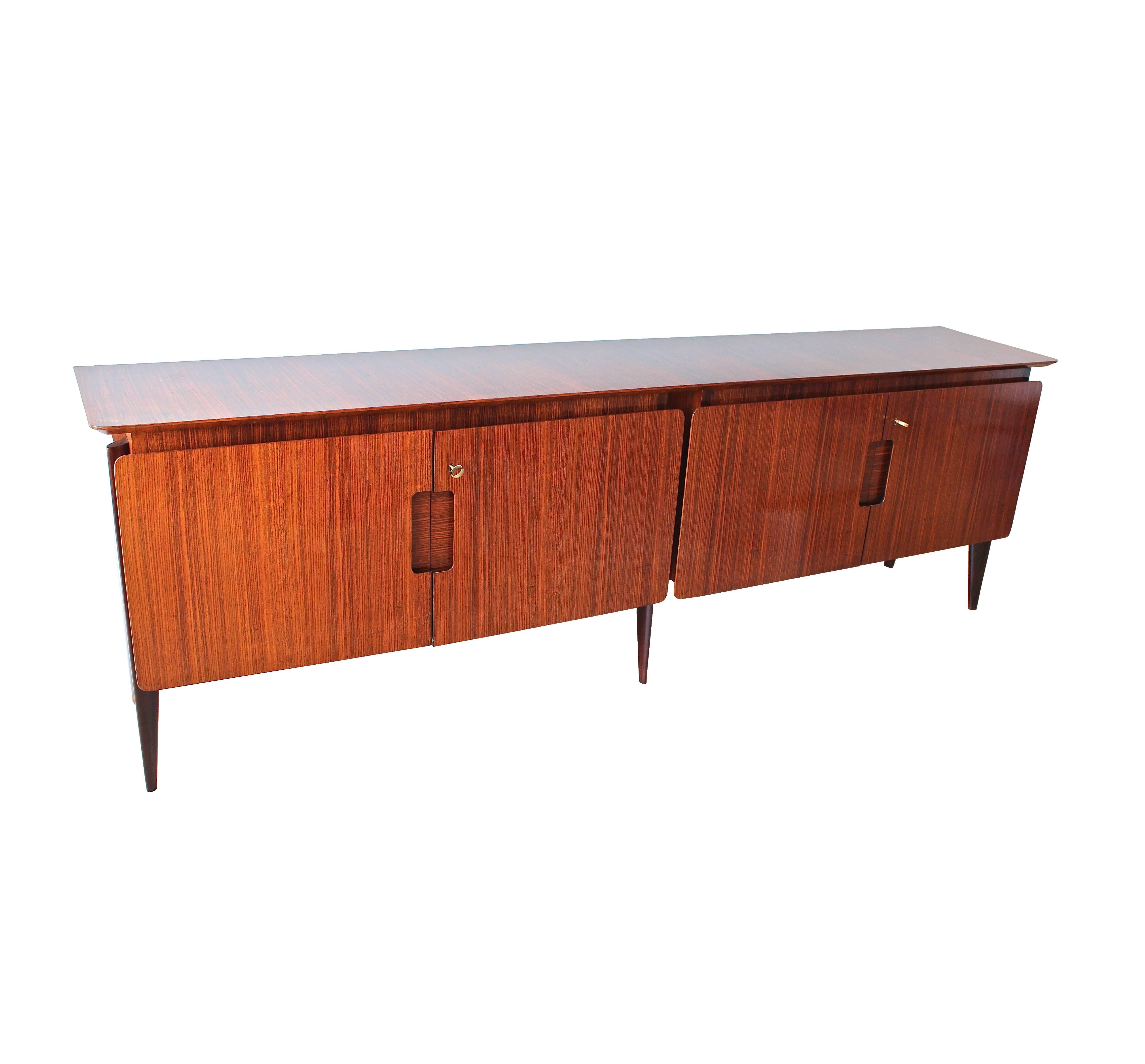 Rare four-door sideboard in rosewood by Ico Parisi.
Right side interior has four-drawers with brass handles and the left side interior has a single shelf.
Manufactured by Rizzi, Cantu, Italy and documented in the Archivio del Design di Ico Parisi.