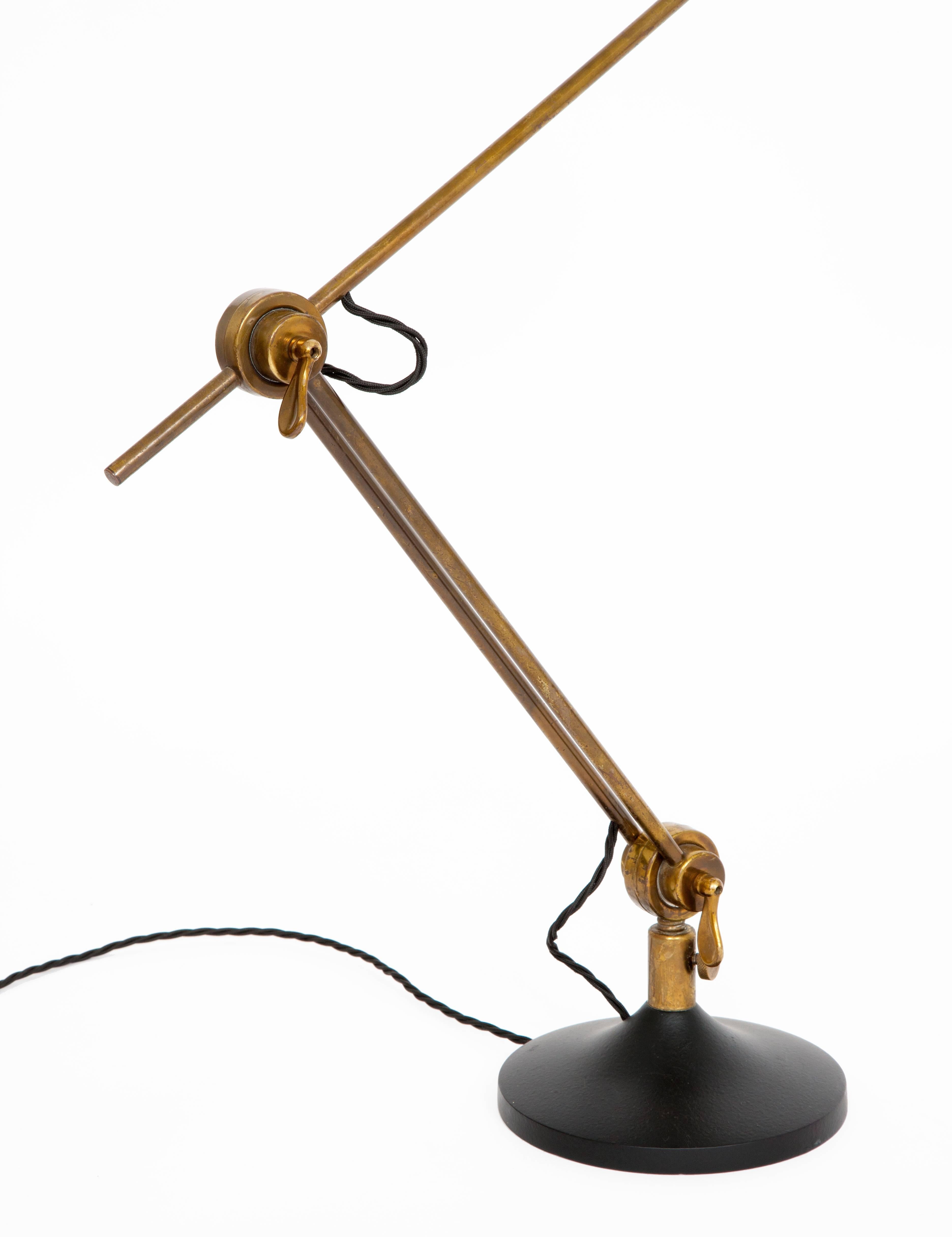 Rare table lamp by Stilnovo in brass and painted metal with an adjustable jointed arm which rotates fully on the base. 
Italy, 1950s.
Dimensions: H: 70 cm W: 59 cm (shade L: 20 cm D: 10 cm).