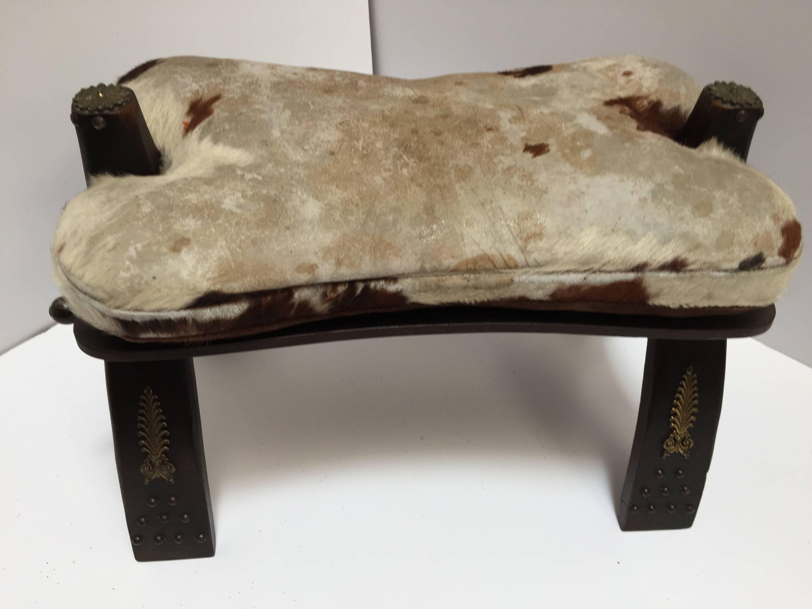 Vintage Moroccan camel saddle shape stool.
Traditionally used to ride camels in the desert, this camel saddle could be used as a foot stool or just as an accent piece in any room.
Wooden base is inlaid with brass floral decoration.
Moroccan