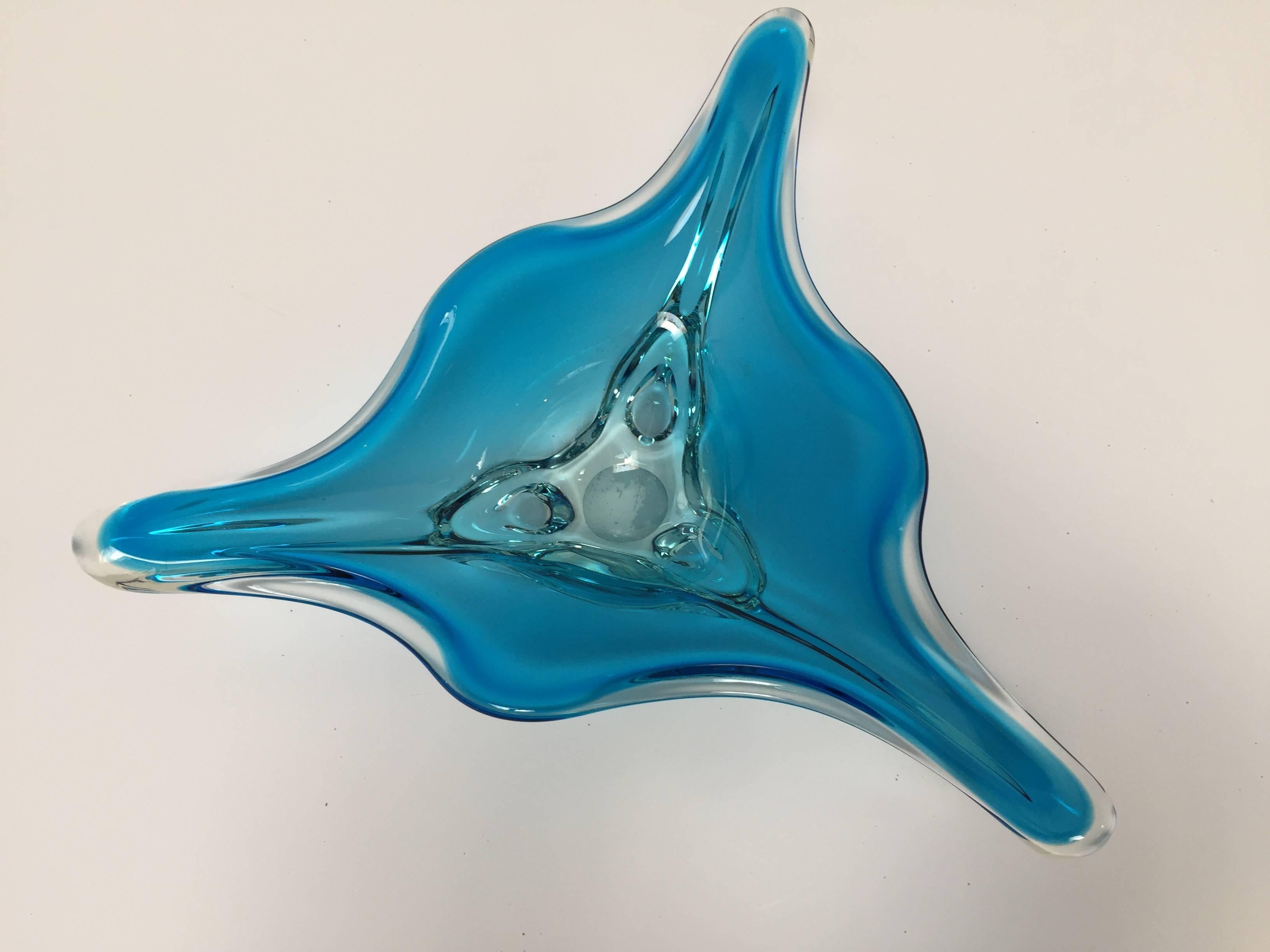 This large exquisite modern decorative handblown Murano art glass bowl with a radiating stylized trefoil design in an amazing aqua blue glass and clear glass.
Beautiful Murano Mid-Century handblown decorative bowl in a thick elongated triangular