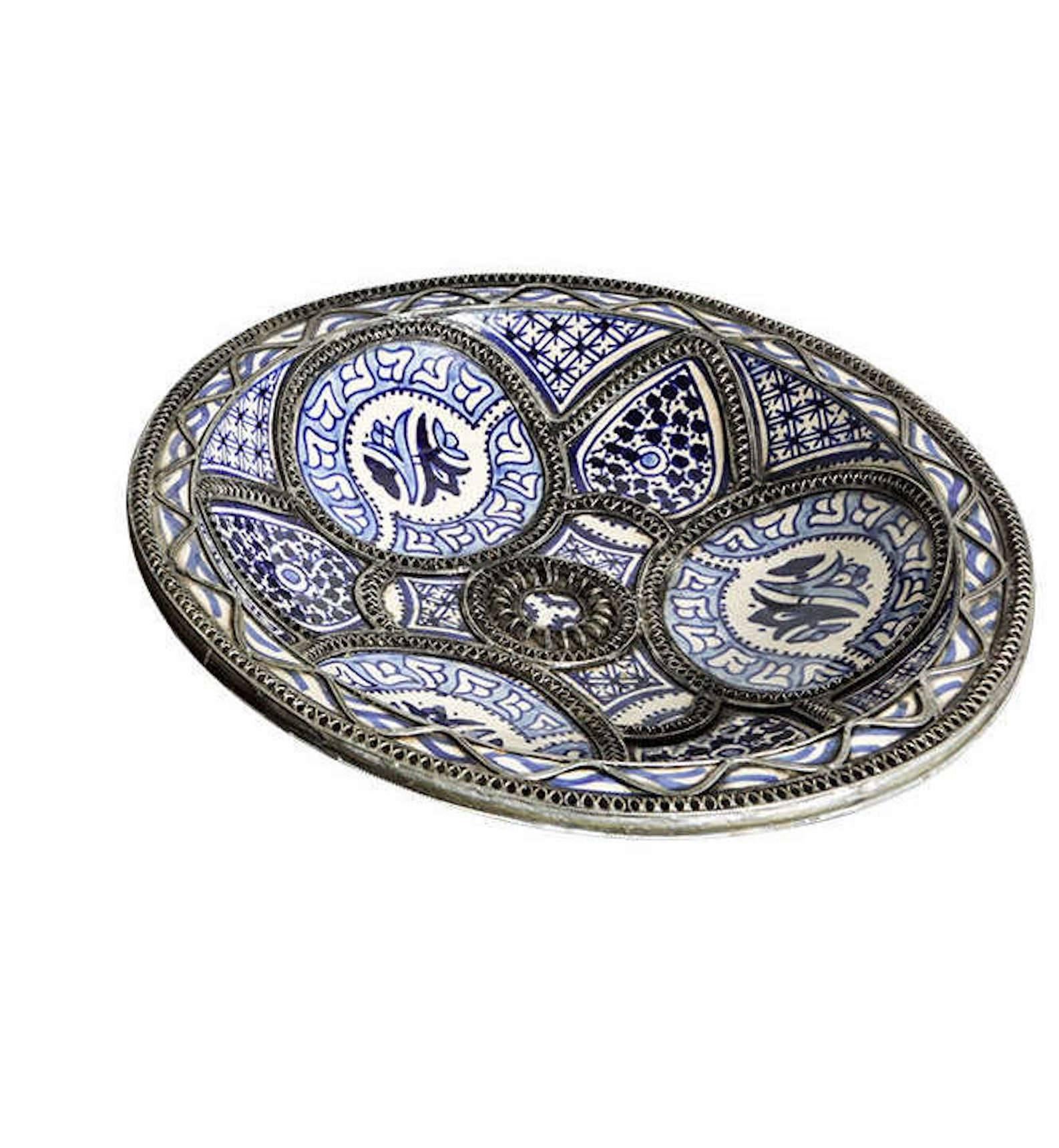 Handcrafted large Moroccan blue and white decorative ceramic plate from Fez. Bleu de Fez, very nice designs hand-painted by artist in Fez.
Geometrical and floral designs and adorned with nickel silver filigree designs.