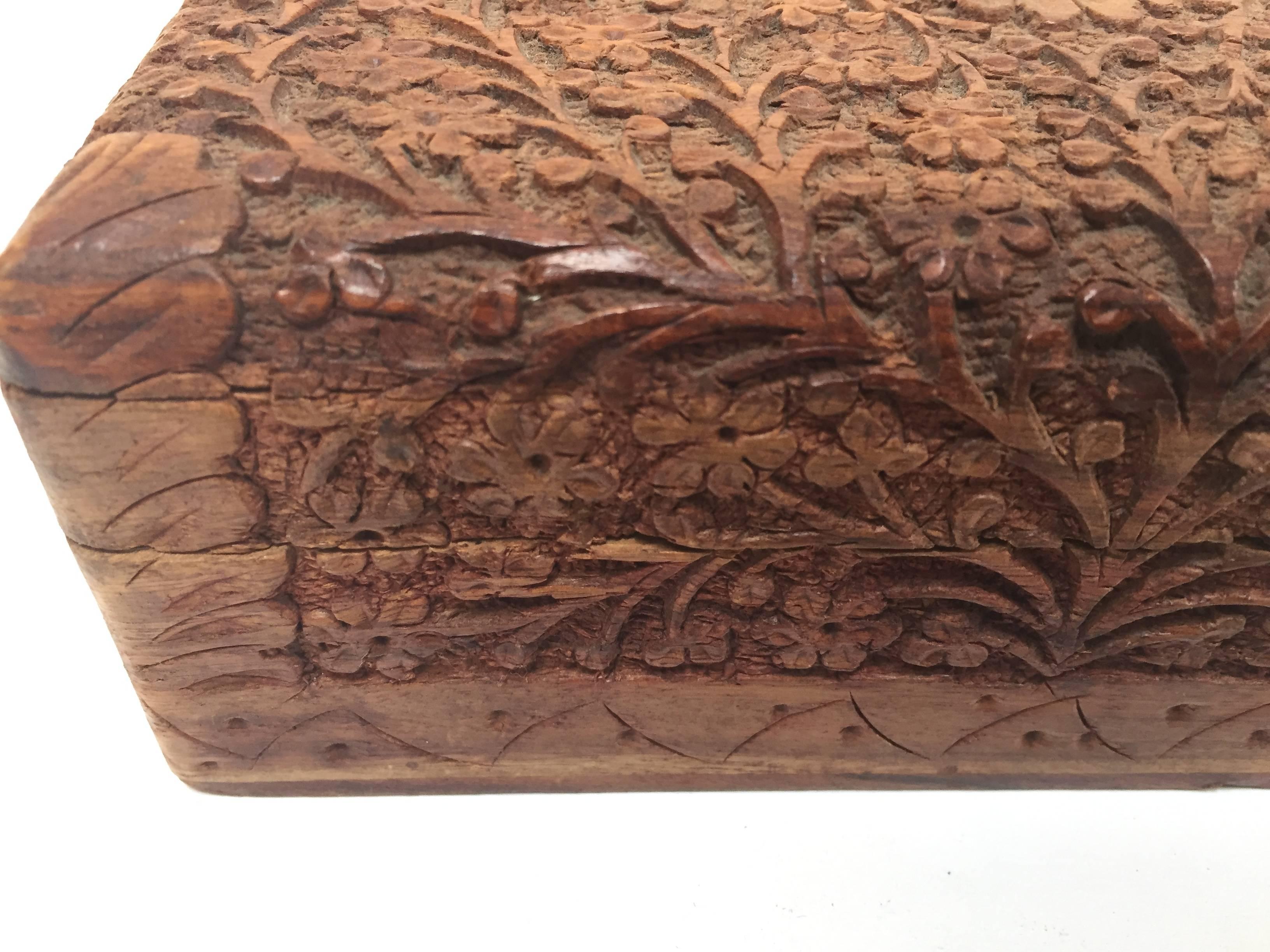 Boîte en bois sculpté Anglo Raj du début du 20e siècle, richement décorée dans son ensemble d'arabesques et de sculptures florales.
Le couvercle à charnière présente une sculpture en relief peu profonde et l'intérieur est tapissé de velours rouge
