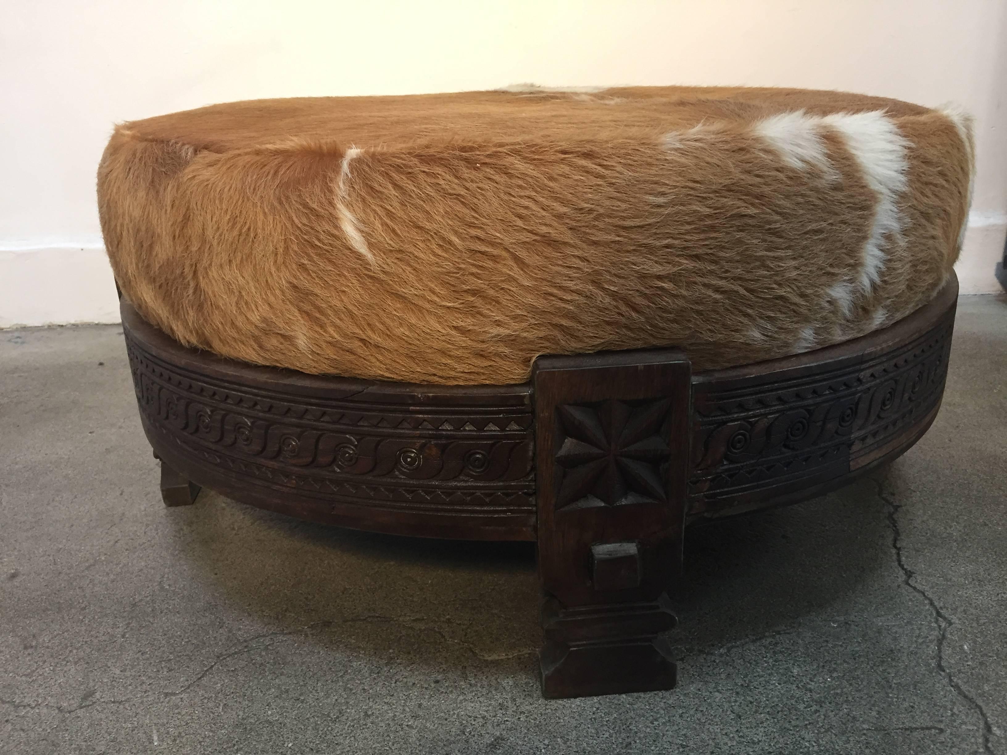 
Large Moroccan ottoman with cow hide seated in a hand carved wood Indian grinder tribal table.
Handcrafted of wood and iron, hand-carved with geometric African tribal design.
Great to use for any Moroccan style or Bohemian design project.
South