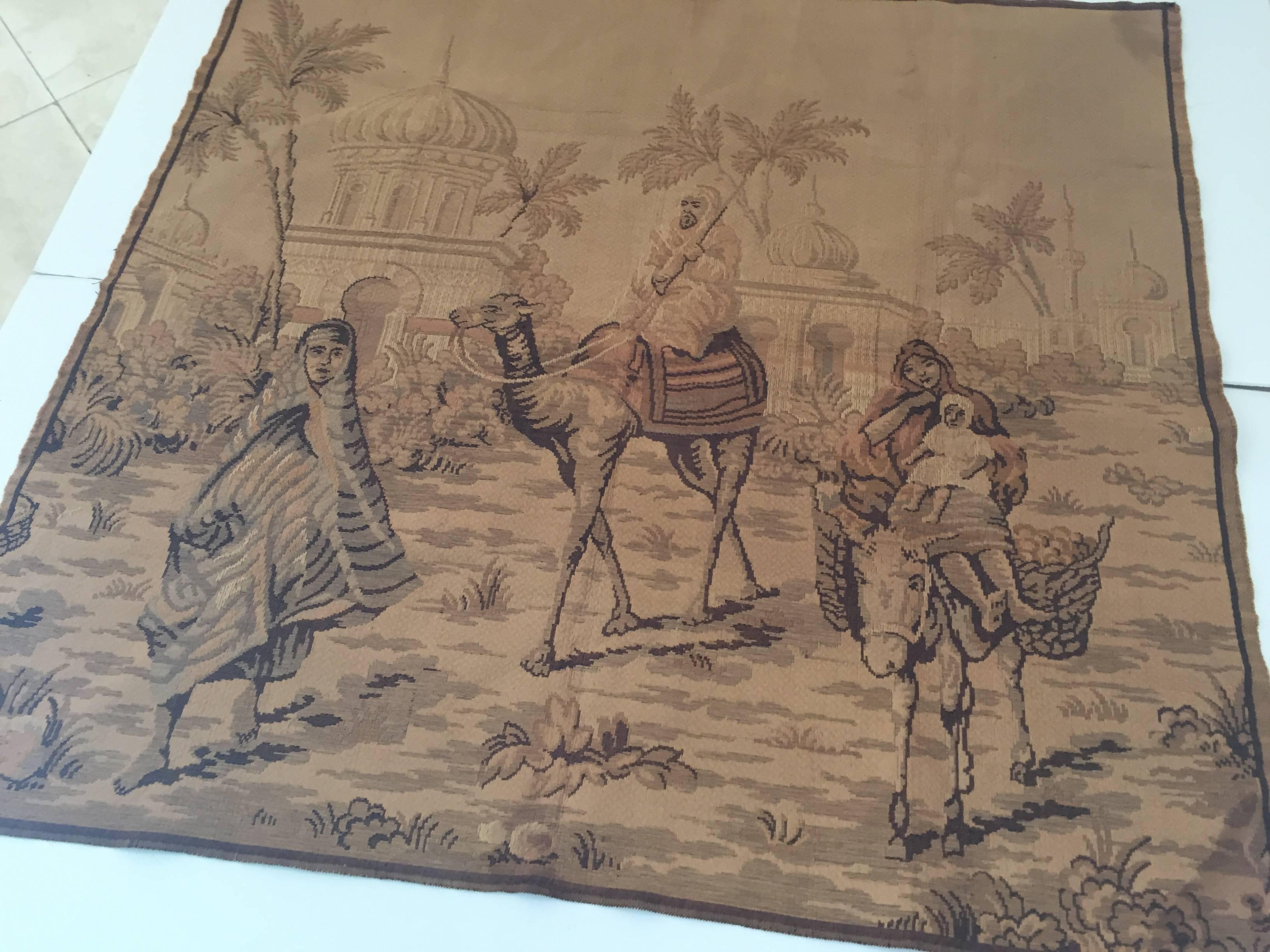 Large Aubusson style Tapestry with an orientalist 19th century scene depicting Arabs figures and Middle Eastern Moorish architecture in the background.
Probably a scene in North Africa, Morocco, with a master on camel and women on a donkey and