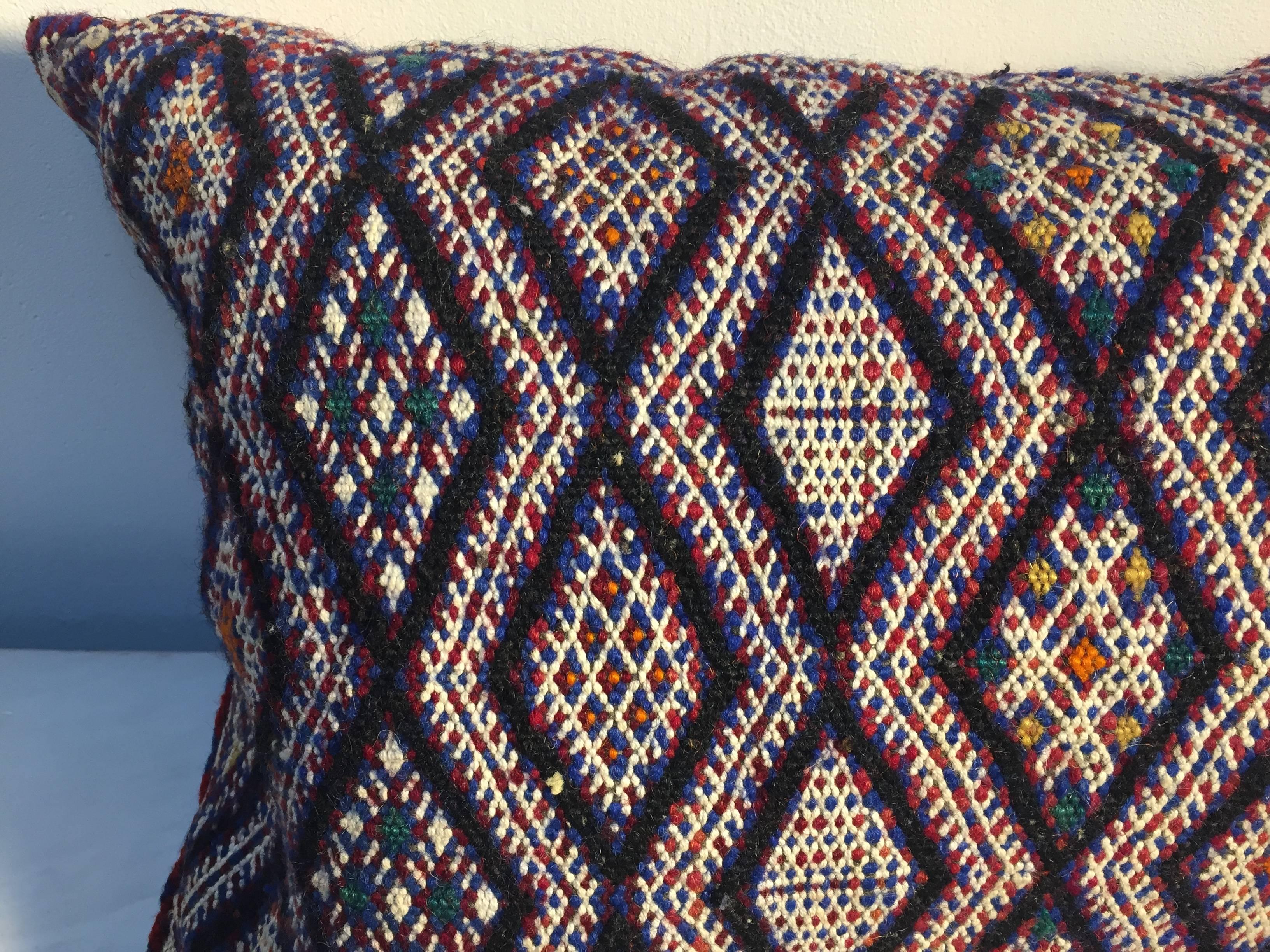 Moroccan Berber handwoven tribal throw pillow made from a vintage flat-weave rug. 
The front and the back are made from a different rug, front is more elaborate and back is more plain. 
Geometric African tribal designs in blue, white red, back is