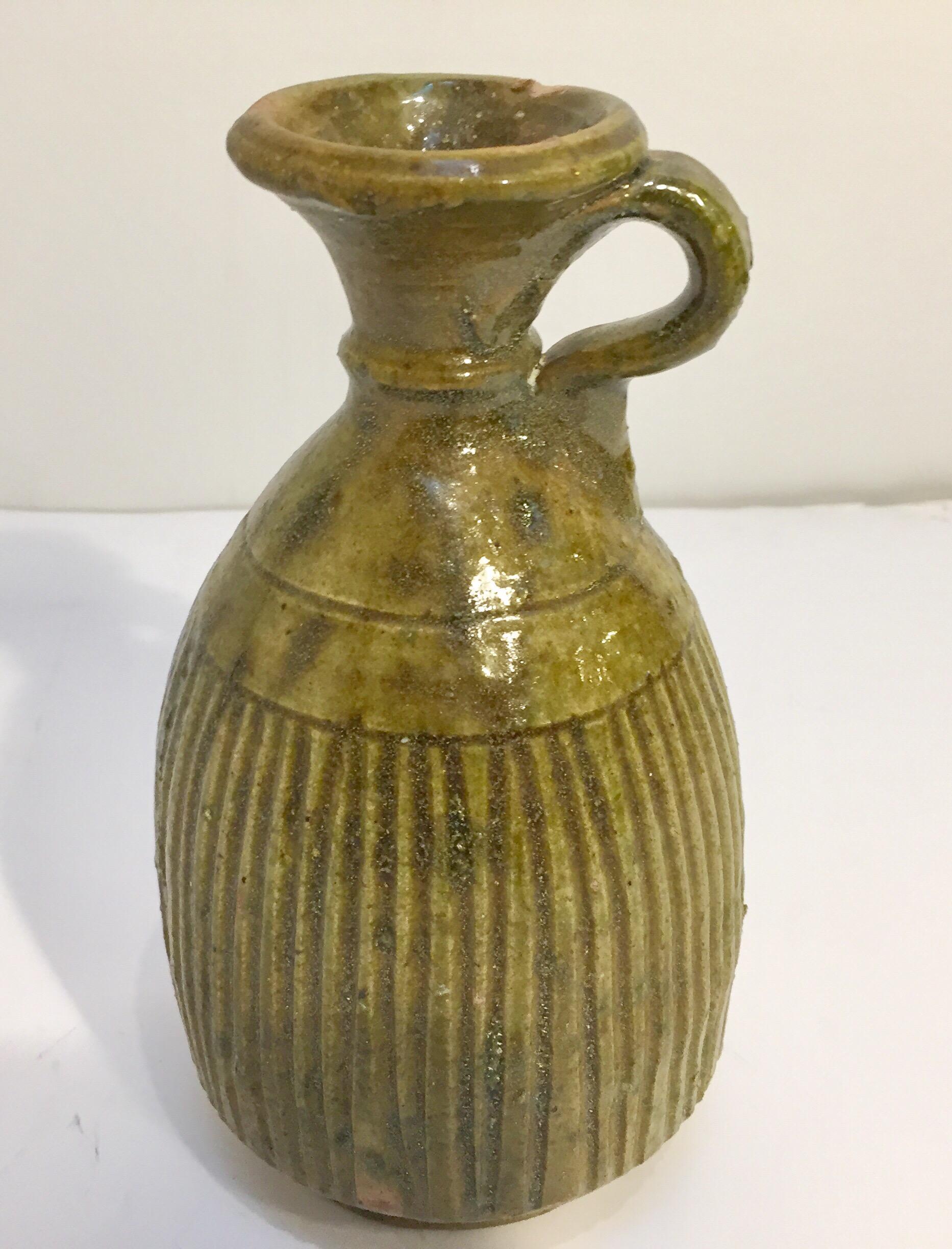 Moroccan green glazed decorative terra cotta jar used for olive oil.
Wonderful green and brown shimmering that can be found only in south Morocco in the village of Tamgroute..
These green Jars were used to store olive oil, vinegar, butter, the