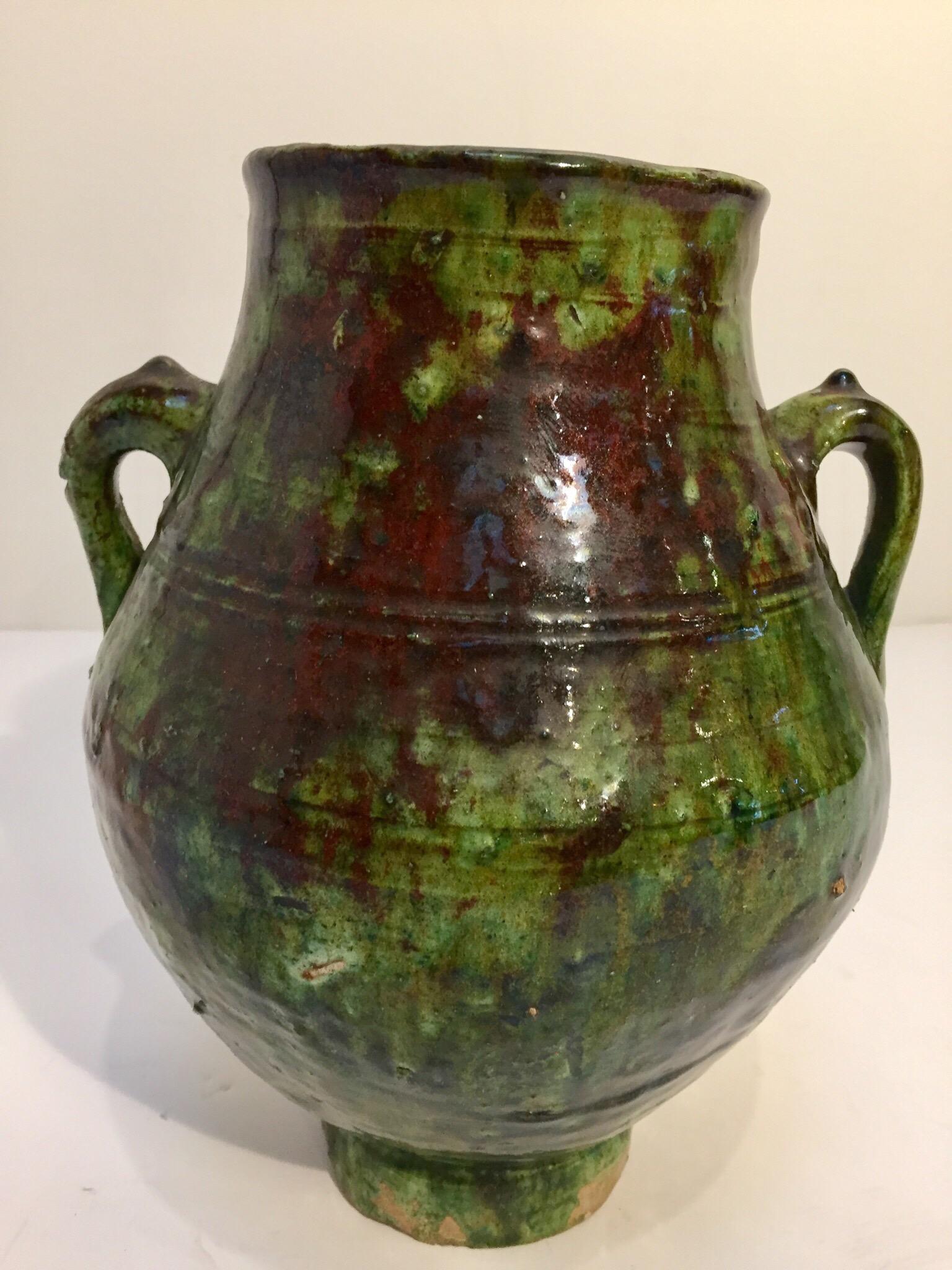 Moroccan Berber green glazed decorative terra cotta jar with handles.
Wonderful green and brown shimmering that can be found only in south Morocco in the village of Tamgroute..
These vintage tribal handcrafted green jars were used to store olive