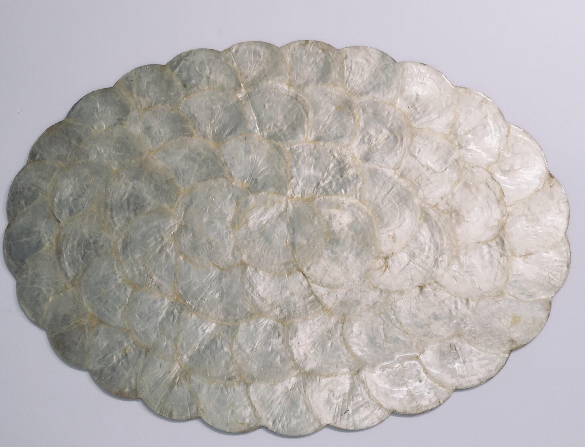 Set of six capiz pearl shell scalloped edge oval placemats
Luminous, beautiful pearl shell color.
The reverse of these placemats is cork. 
These would make a beautiful, tropical and elegant table setting. 
Late 1970s or early 1980s. Made in the
