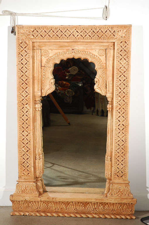 Anglo Indian hand-carved Moorish Rajasthani wooden mirror in rectangular shape with a horseshoe arch.
Made from an old Indian architectural window.
Heavily hand-carved with foliate spays, columns and geometric design, amazing craftsmanship.
Great
