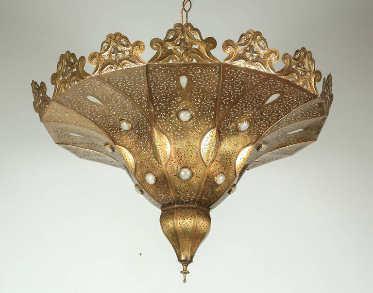 Moroccan Moorish style brass chandelier in Alberto Pinto style.
This Pasha Moroccan chandelier is handmade of polished gold repousse and open work brass with inlay handblown decorative milky glass.
Delicately handcrafted, metal open work,