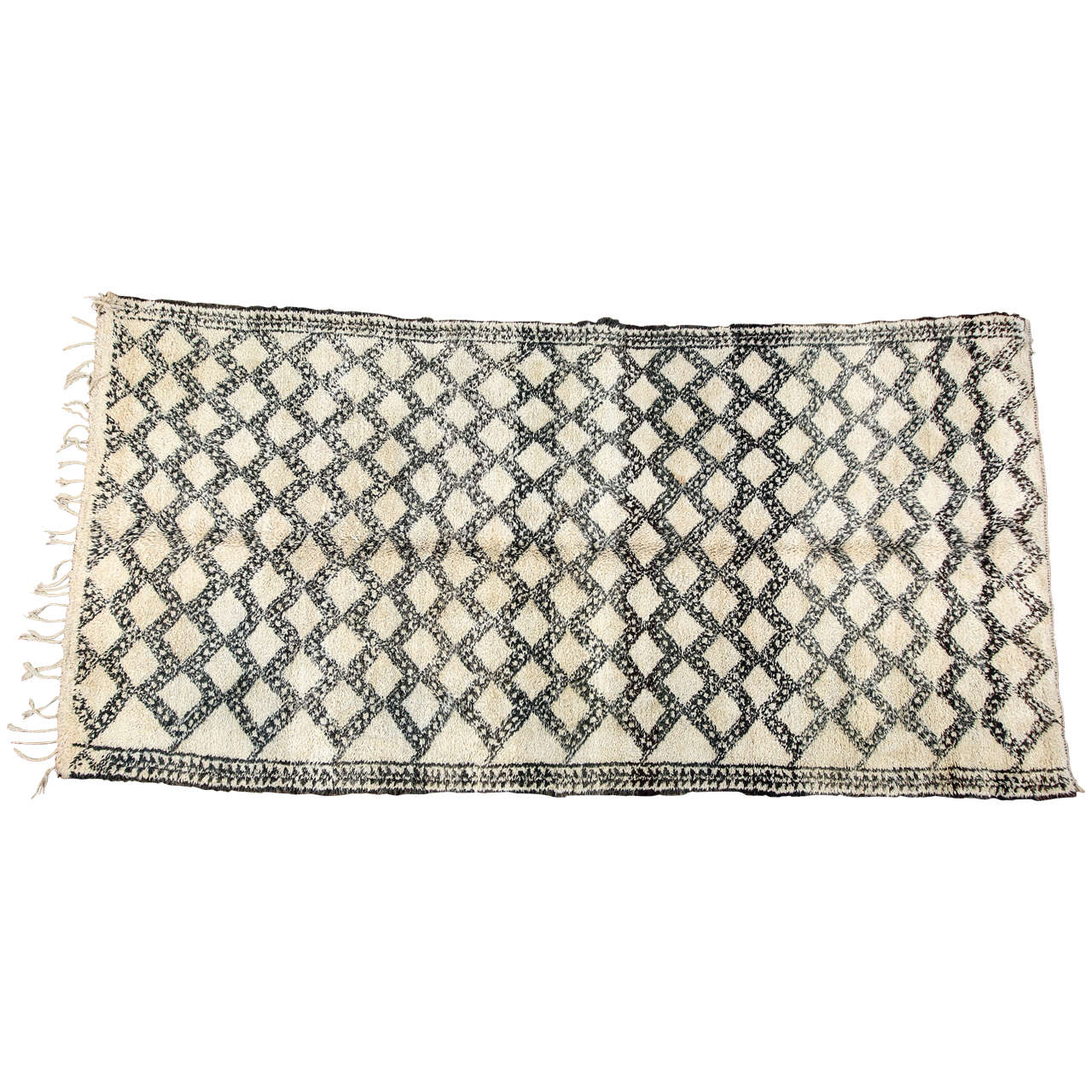 Vintage tribal Moroccan shaggy and lush Berber rug from the Beni Ouarain tribes from the middle atlas mountains of Morocco, North Africa.
Moroccan shaggy tribal rug handwoven with organic un-dyed ivory wool with asymmetrical diamond shape designs
