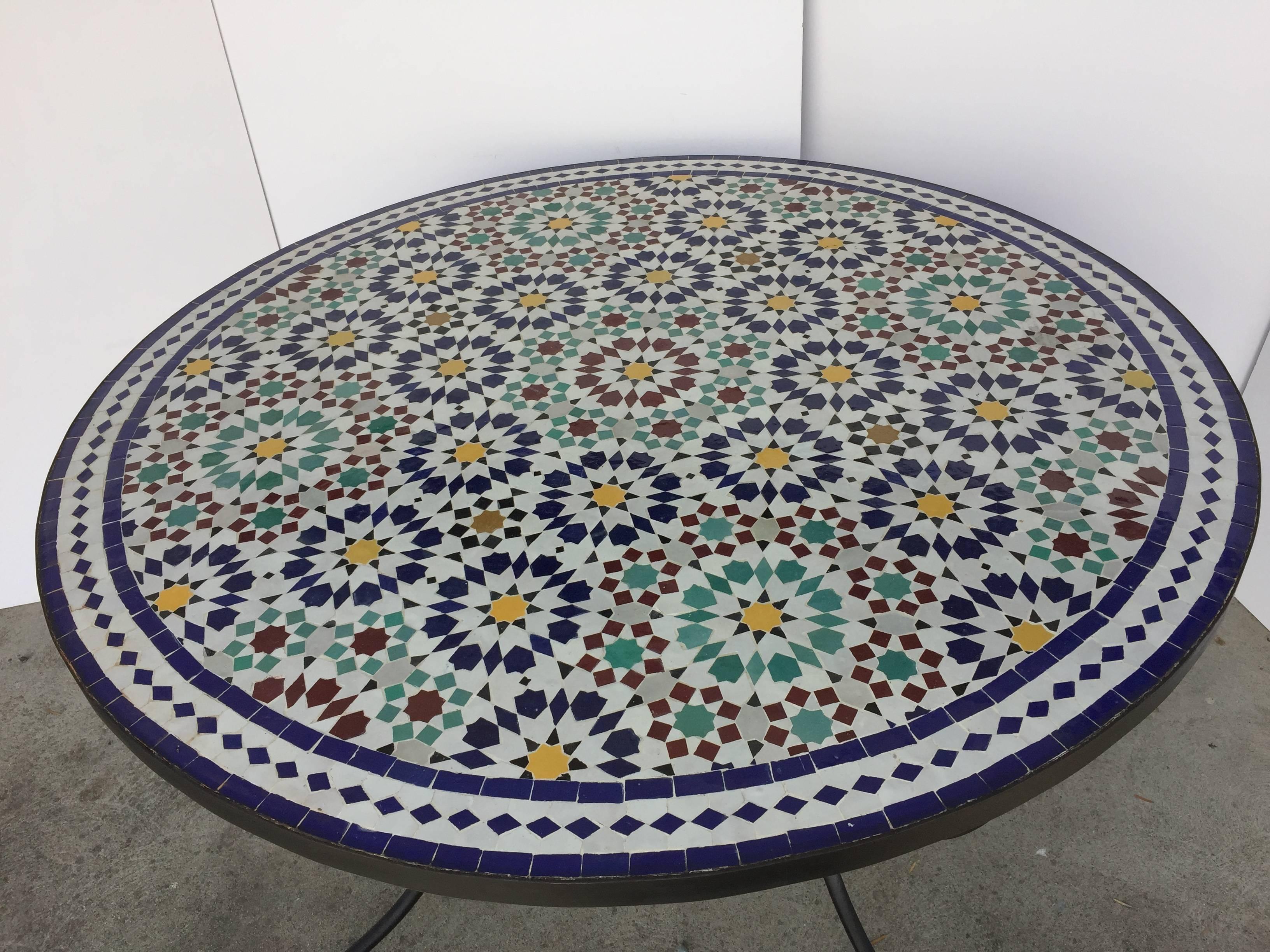 Moroccan round mosaic tile table delicately handcrafted by expert artisans in Fez, Morocco, using reclaimed old glazed tiles inlaid in concrete with traditional Islamic Moorish geometrical design in white, blue, red, green and green colors.
Moroccan