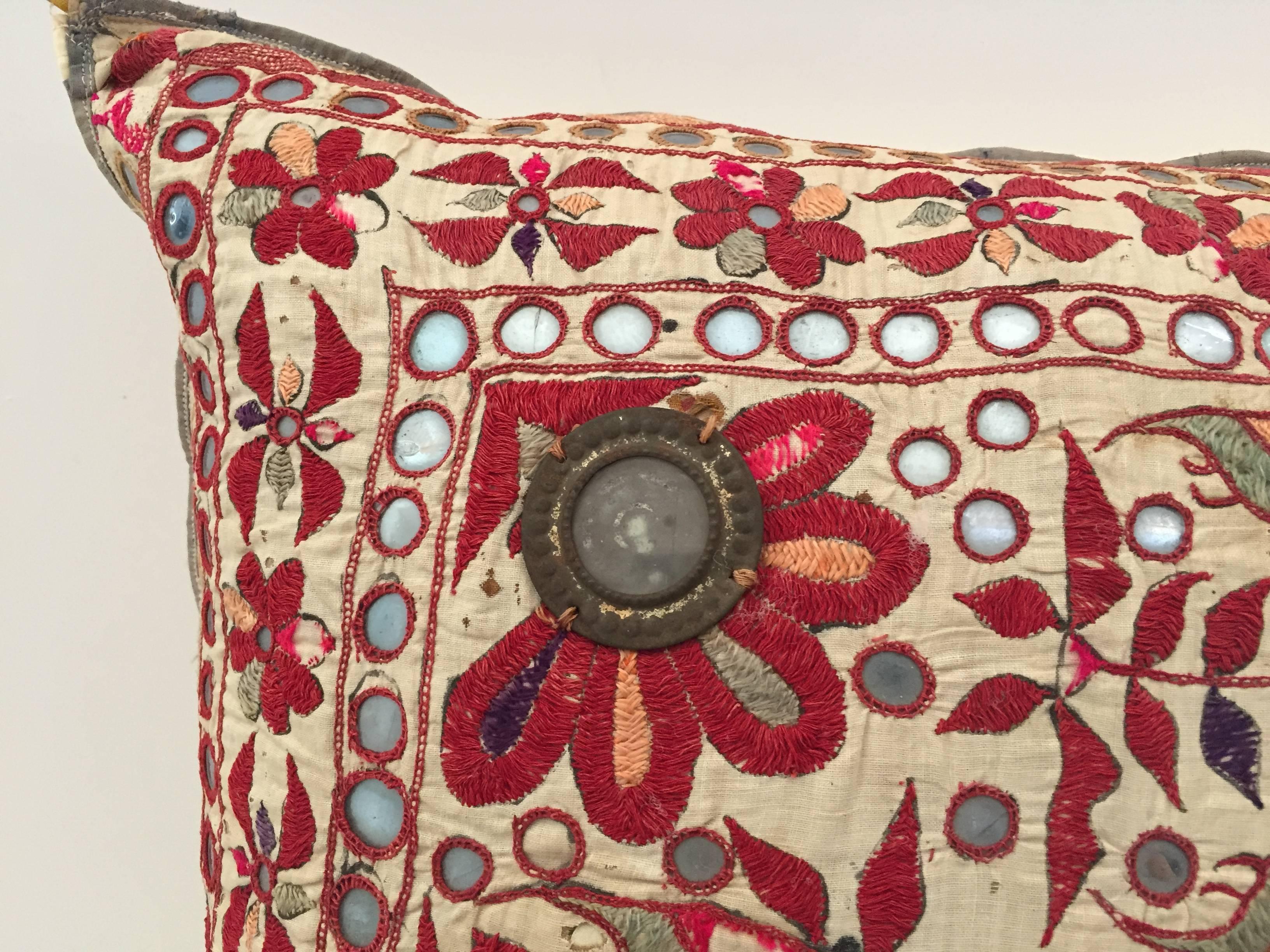 Bunt besticktes Rajasthani-Textil aus dem 19. Jahrhundert in Form eines dekorativen Kissens.
Handgefertigt mit floralem Muster, gestickt mit Seidenfaden und verziert mit kleinen Metallspiegeln, die blühende Blumen und Vögel darstellen.
In den Farben