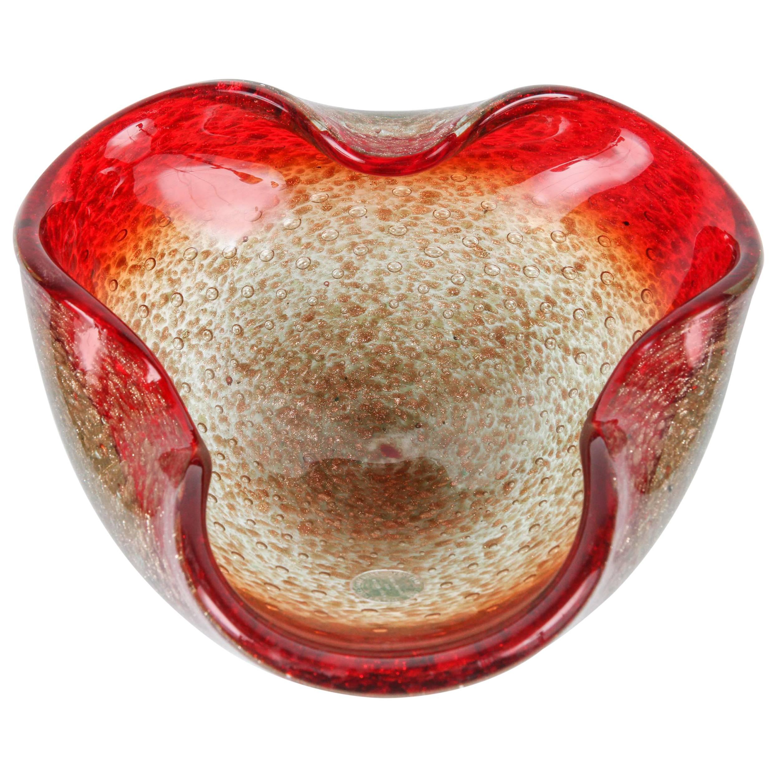 Gorgeous Murano Venetian handblown glass flower shaped bowl or ashtray. Sculptural organic open flower form in ruby red and beautiful gold flecks decoration in aventurine technique.
Stunning piece of Mid-Century Murano glass attributed to Carlo