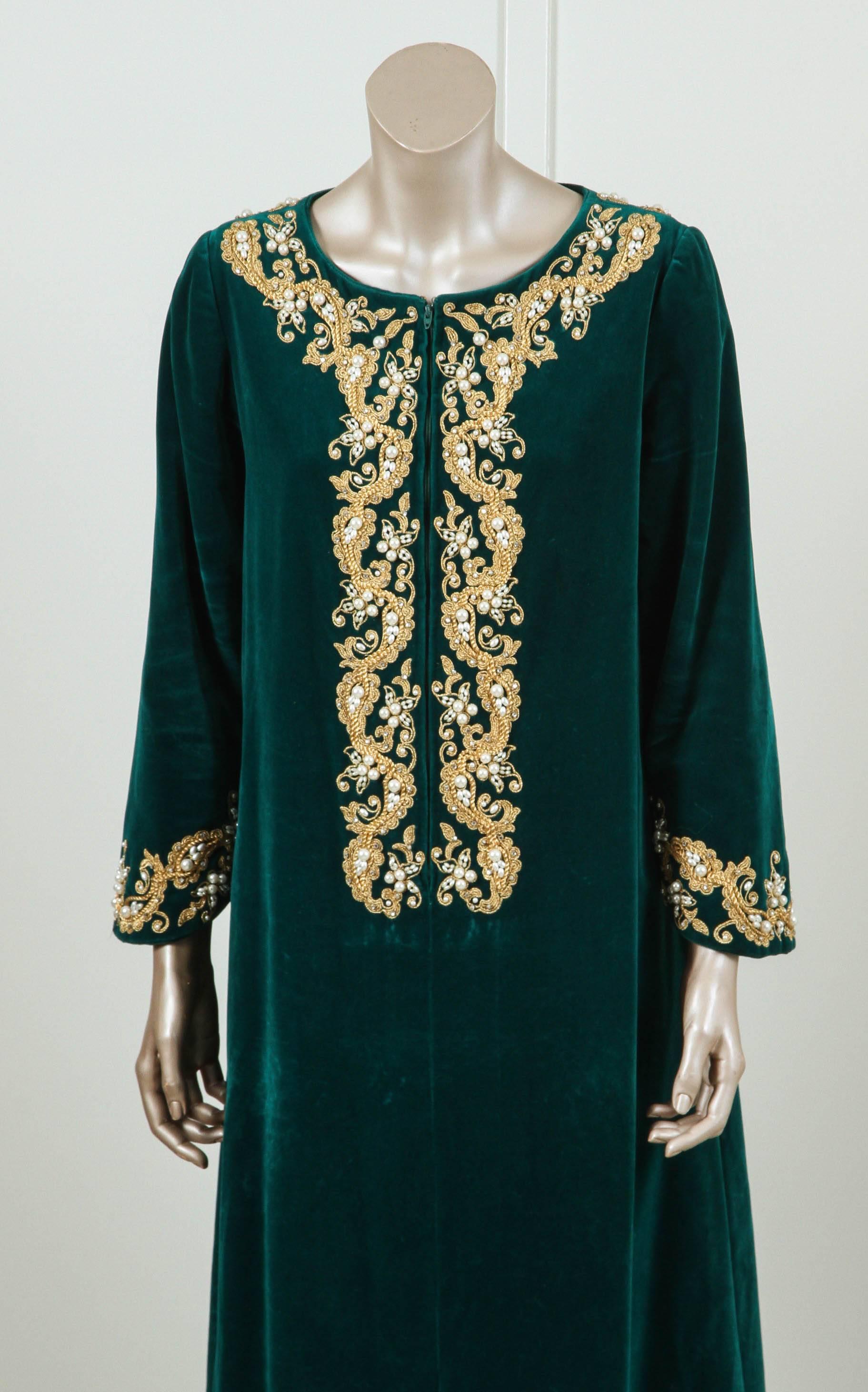 Vintage I. Magnin 1970s silk velvet caftan with embroidered neckline and sleeve embellished and intricately embroidered with pearls and gold threads.
Zipper in front.
This designer dark green color silk velvet Bohemian style kaftan is embroidered