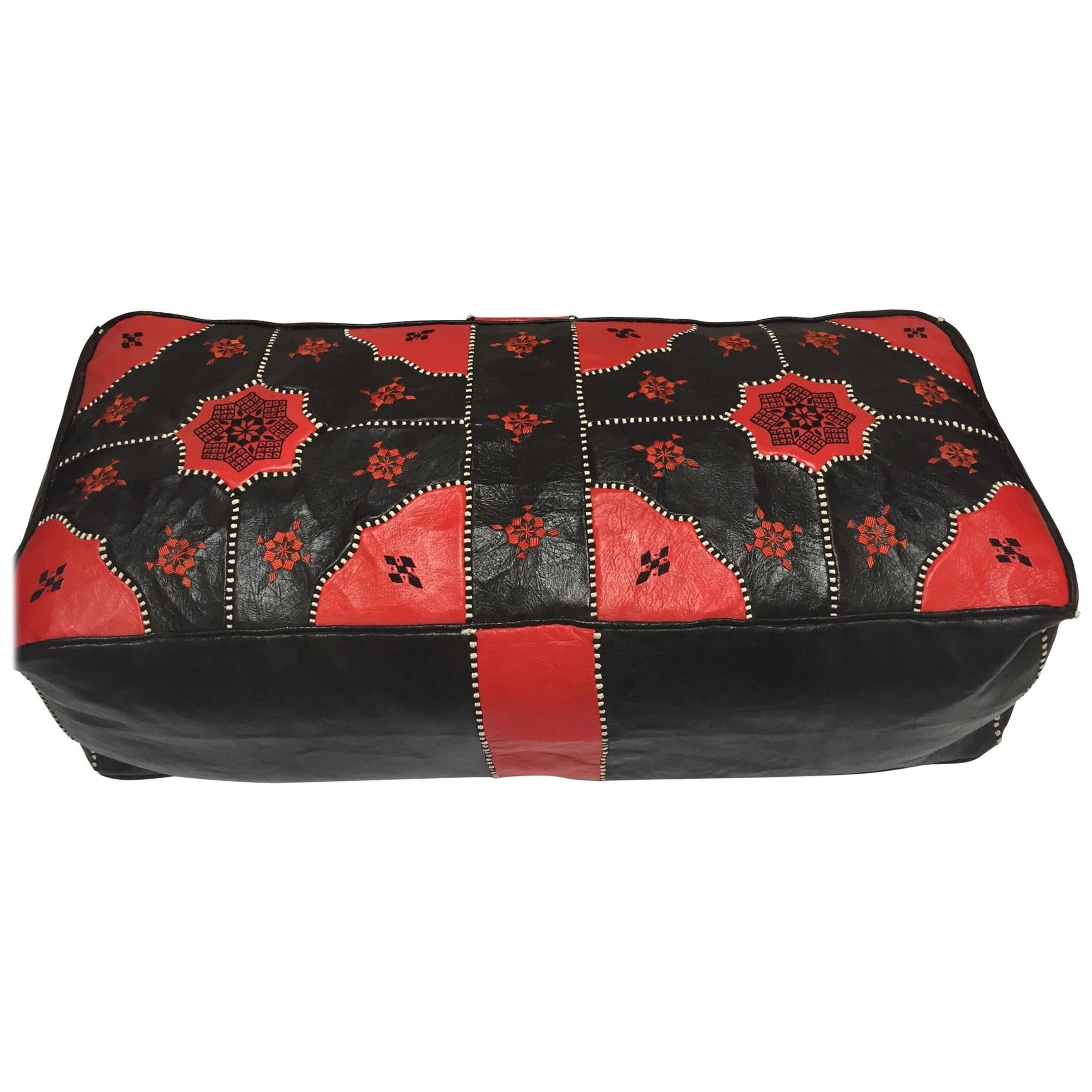 Large vintage red and black hand tooled leather Moroccan ottoman.
Rectangular shape pouf in red and black leather embroidered with black and white silk threads.
Handcrafted by skilled artisans in Marrakech, Morocco, 
circa 1970s.