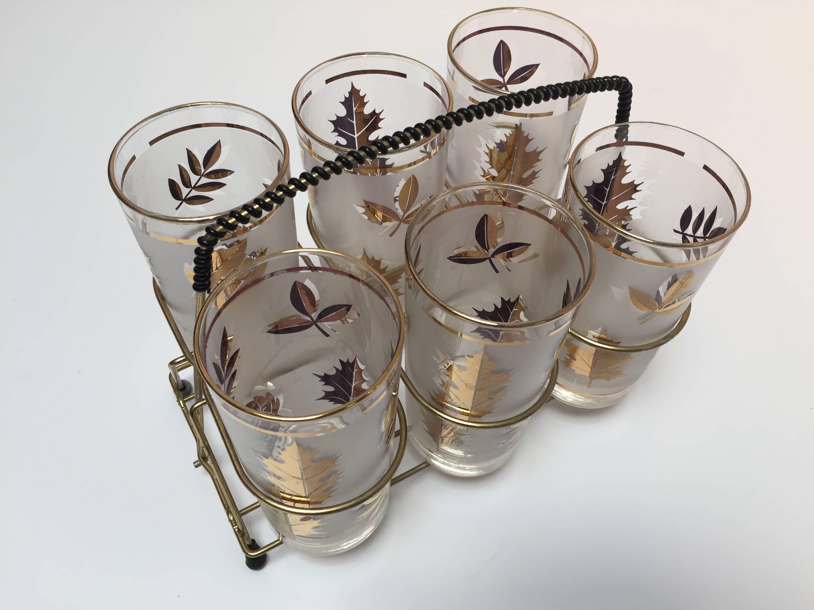 Elegant vintage Libbey barware frosted glasses with leaves pattern in a gold finish.
Set includes six highball glasses in a polished brass cart with a handle. Mid-Century Modern vintage glasses.
Hollywood Regency style.
The pattern on frosted