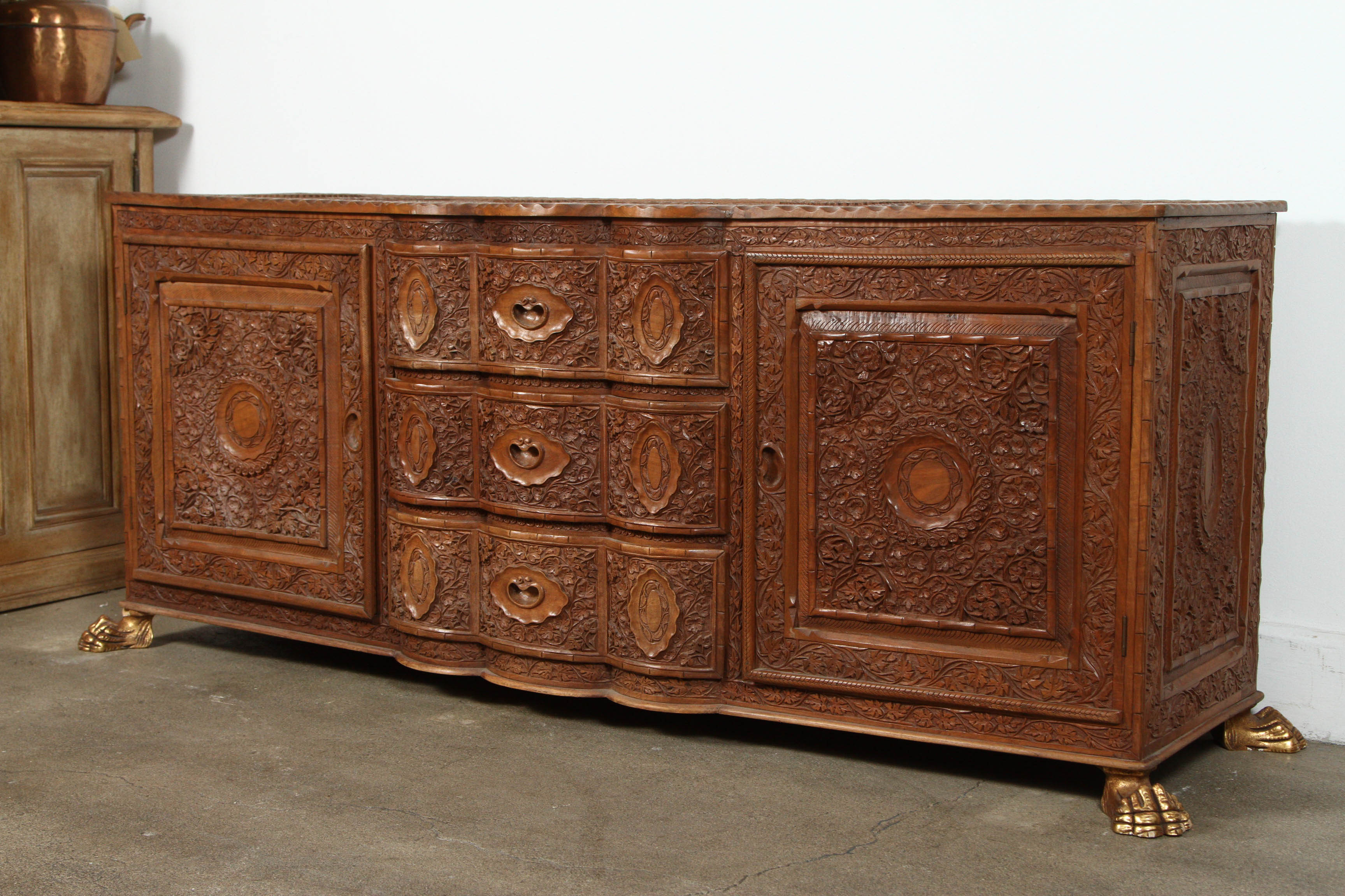 Very special and unique, fabulous Indonesian sideboard, great quality and very fine hand carved chest of three drawers with two doors.
Very interesting work, Anglo-Indian style flower designs all-over sitting on four gilded claw feet. Handmade