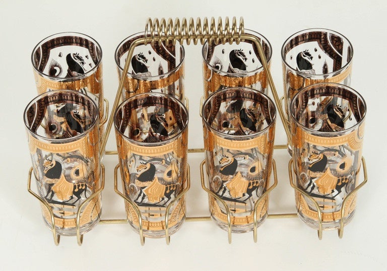 Elegant exquisite vintage set of 8 Collins glasses designed by Fred Press. 
Set includes 8 highball glasses in a polished brass cart with handle.
The glasses are decorated with gold and black stallions.
Perfect vintage condition, with 22 karat