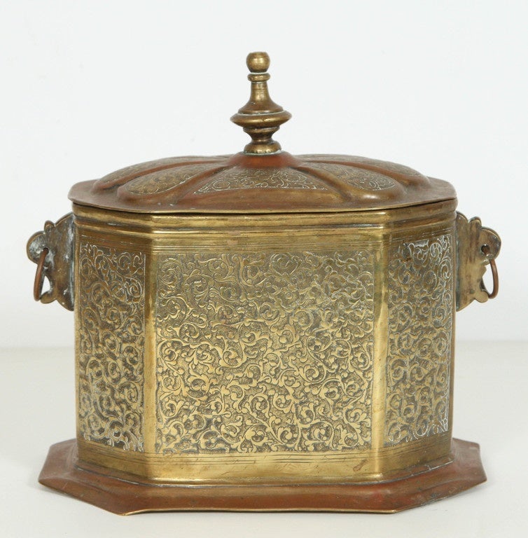 Moroccan Brass Tea Caddy.
Nice Middle Eastern Arabian style hand chiseled brass and copper plated.
Moroccan Octagonal shape, nicely decorated with Moorish foliage designs.
Lid with hinge, and 2 decorative handles.