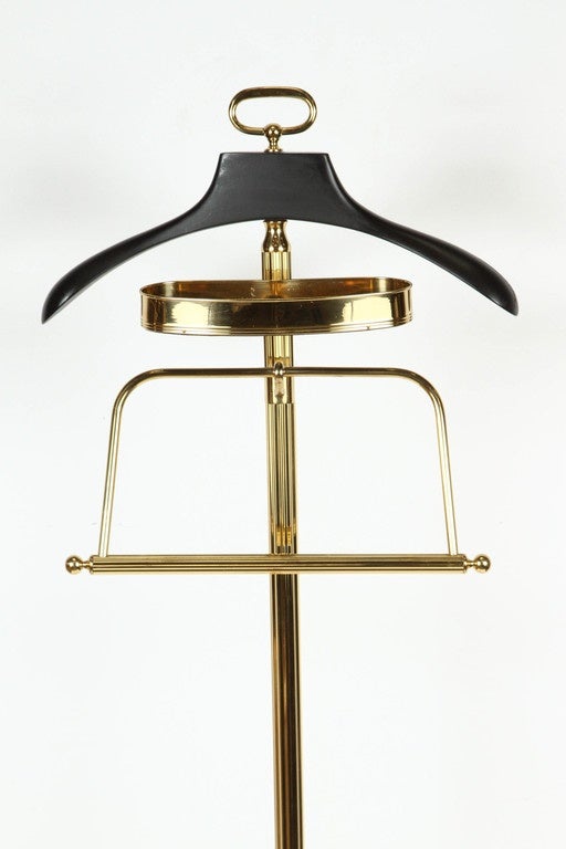 Impressive and stylish mastercraft, made in Italy polished brass valet stand, with coat holder covered in leather, pants and change and jewelry holder. 
On caster base. Perfect for any gentleman's closet or room
Stamped 