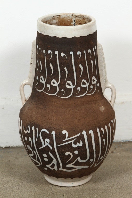 Pair of very decorative brown and ivory handcrafted Moroccan ceramic vases from Fez with two handles chiseled and hand-graved with ivory Arabic poetry calligraphy.
Mouth opening is 5 in.
This kind of ceramic Moorish Spanish style work could be