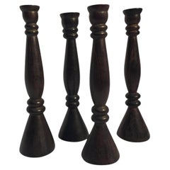 Juego de cuatro candeleros altos de madera tallada a mano