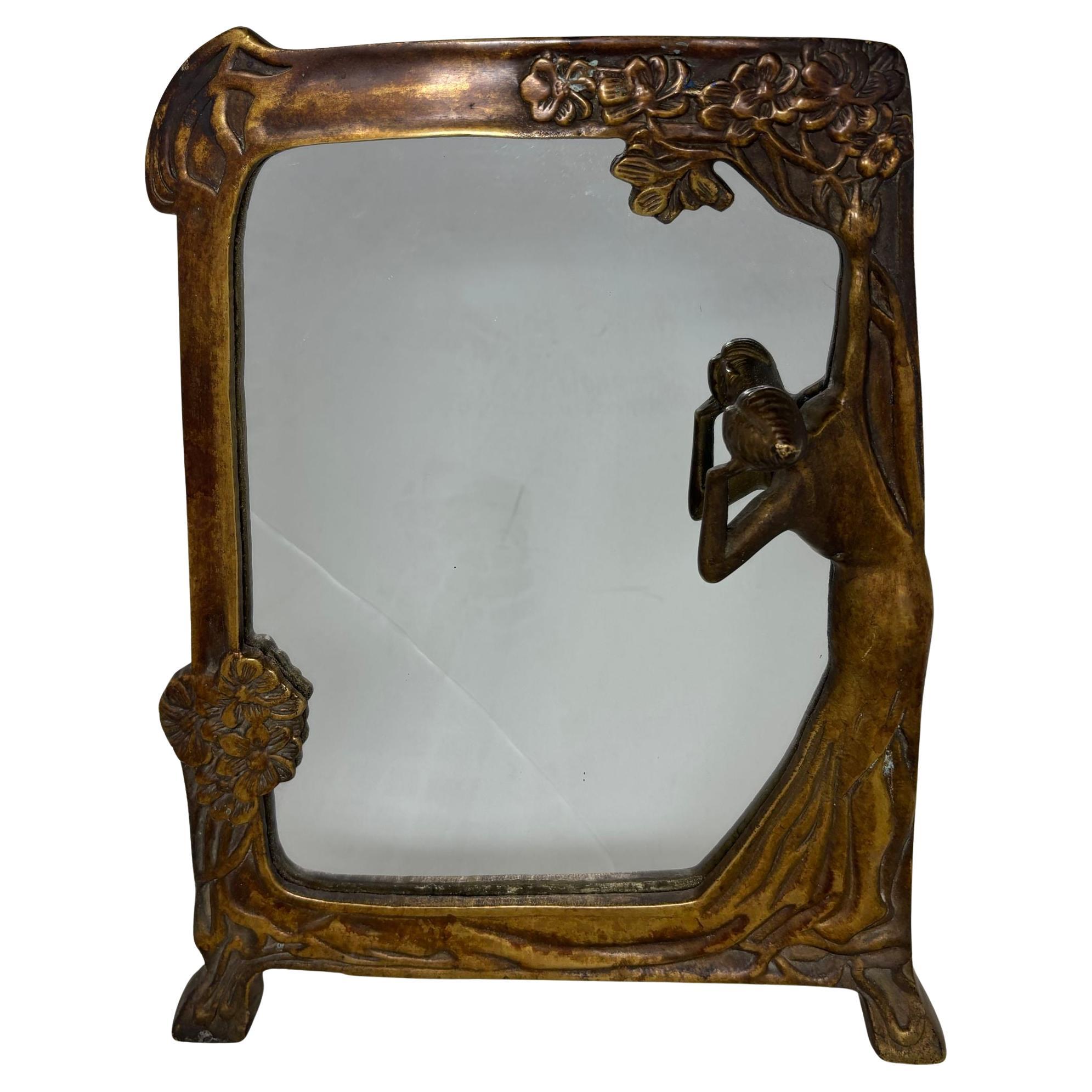 Lady of the Lake Miroir antique en bronze de style Art Nouveau, vers 1930.
Miroir en bronze massif avec une belle jeune femme tenant une branche d'arbre pour s'appuyer alors qu'elle regarde son reflet dans le lac.
