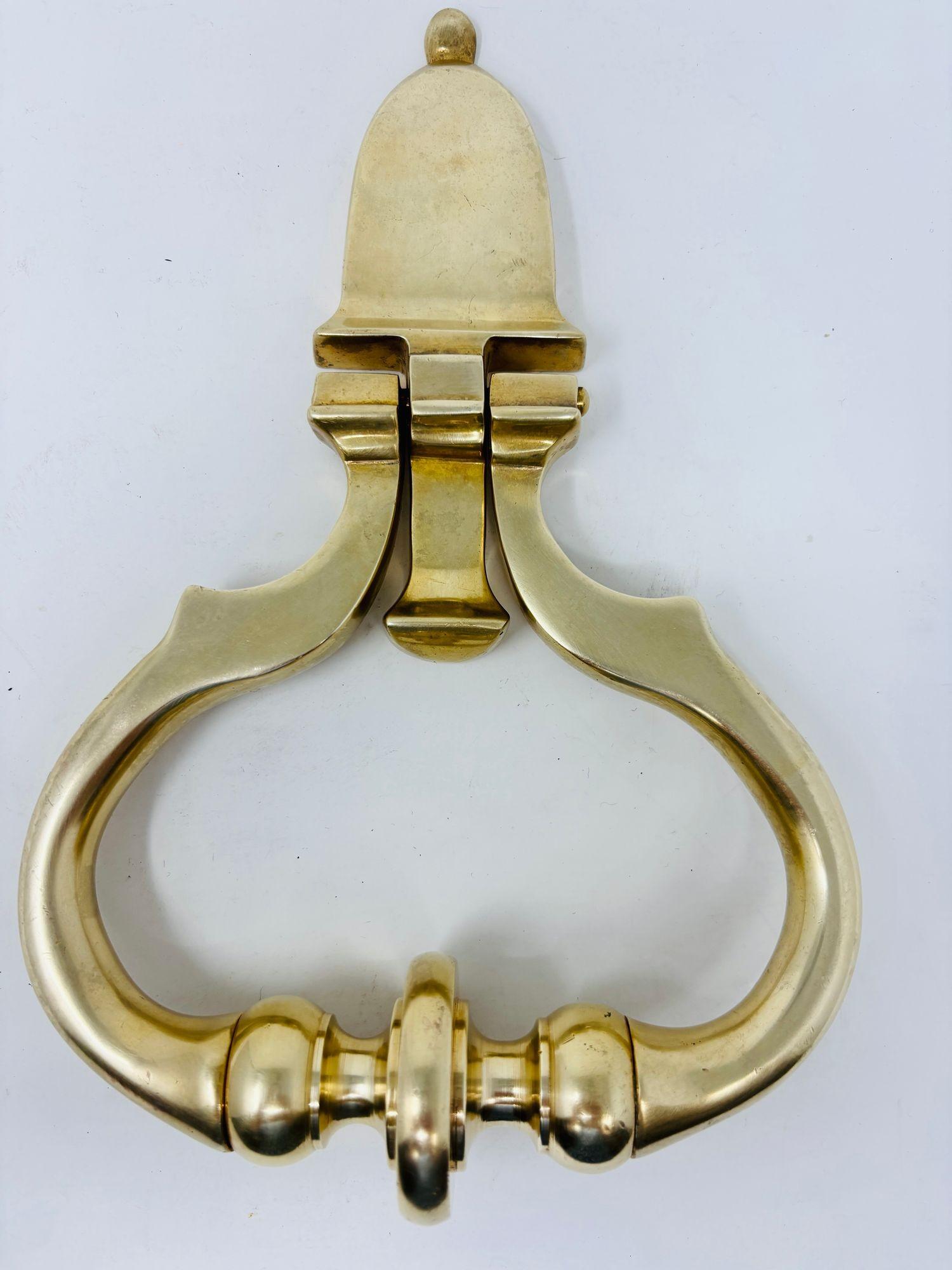 A large solid cast polished brass door knocker sophisticated in shape and design.
A substantial Georgian style early twentieth century brass door knocker.
The piece was acquired from an estate in Beverly Hills, California.
A wonderful piece, either
