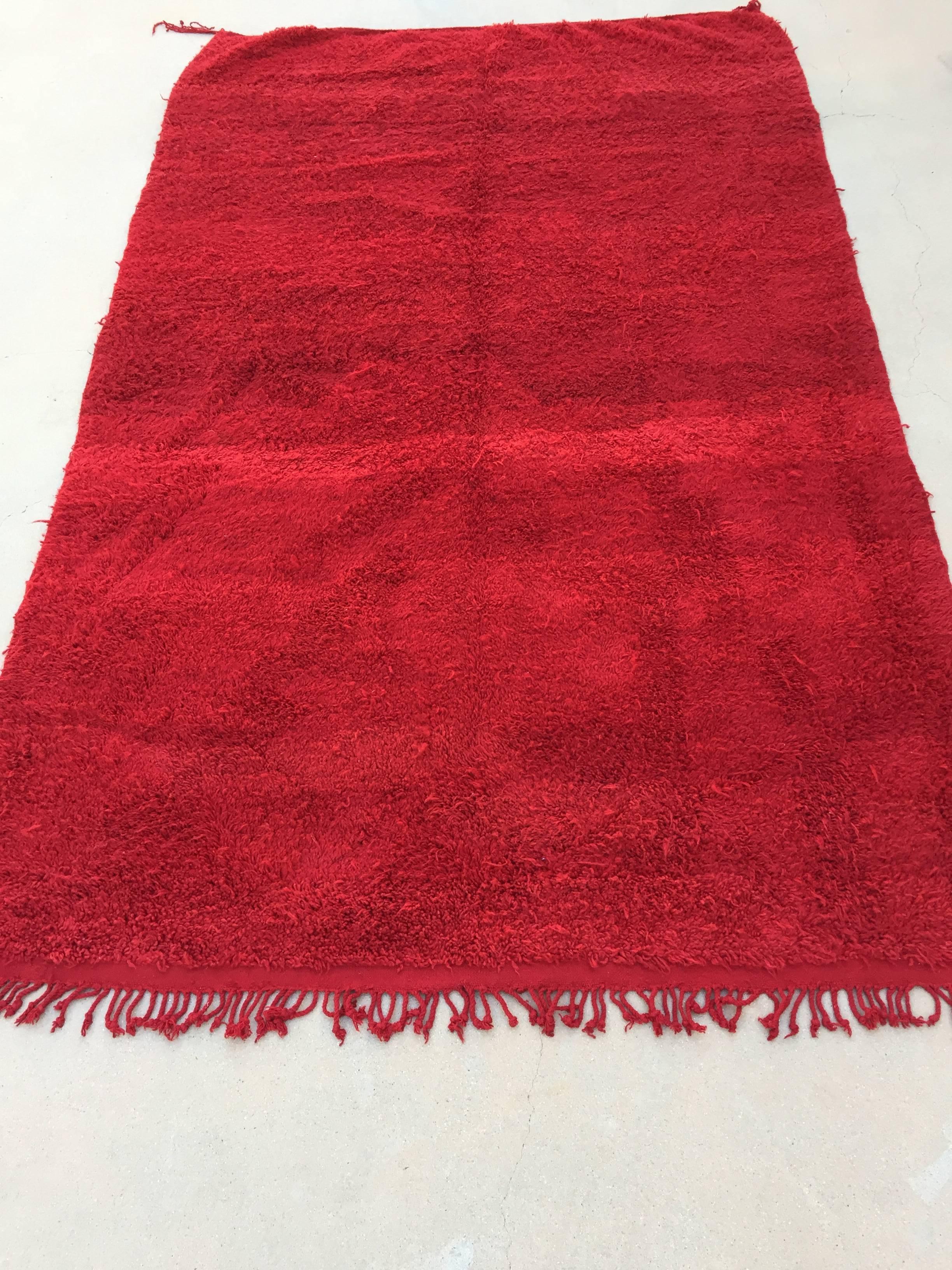 Vintage red tribal Moroccan Berber rug from the Middle Atlas mountains. Monochromatic red rug with variations in color intensity typical for this tribe.
This is a good example with high quality handwoven wool.
Soft and shaggy tribal Bohemian
