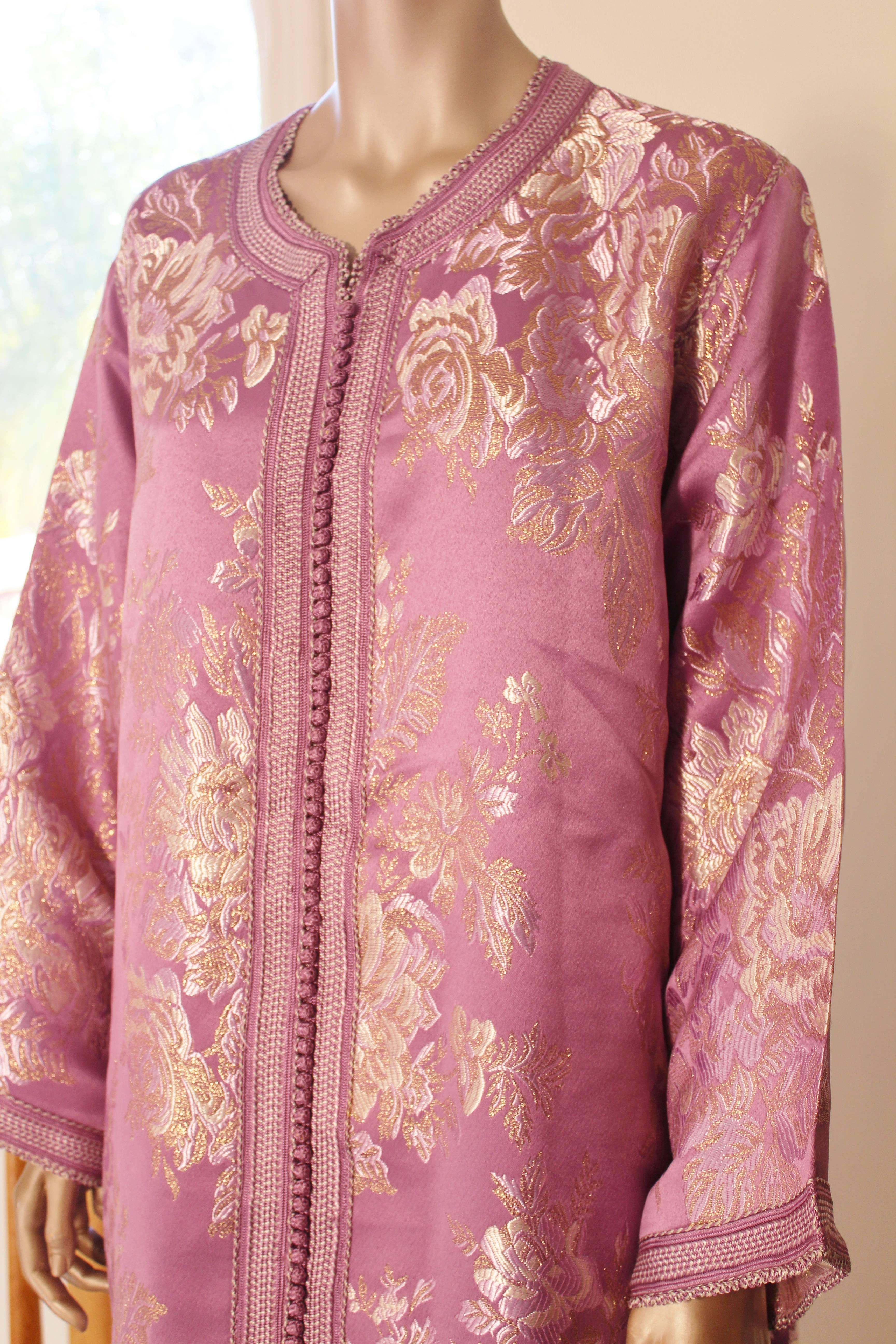Robe caftan exotique marocaine en brocart métallique, circa 1970.
Ce luxueux caftan est conçu avec un tissu métallique doré brillant.
L'avant de l'élégante robe caftan maxi est agrémenté de boutons dorés tissés et de boucles qui descendent au centre