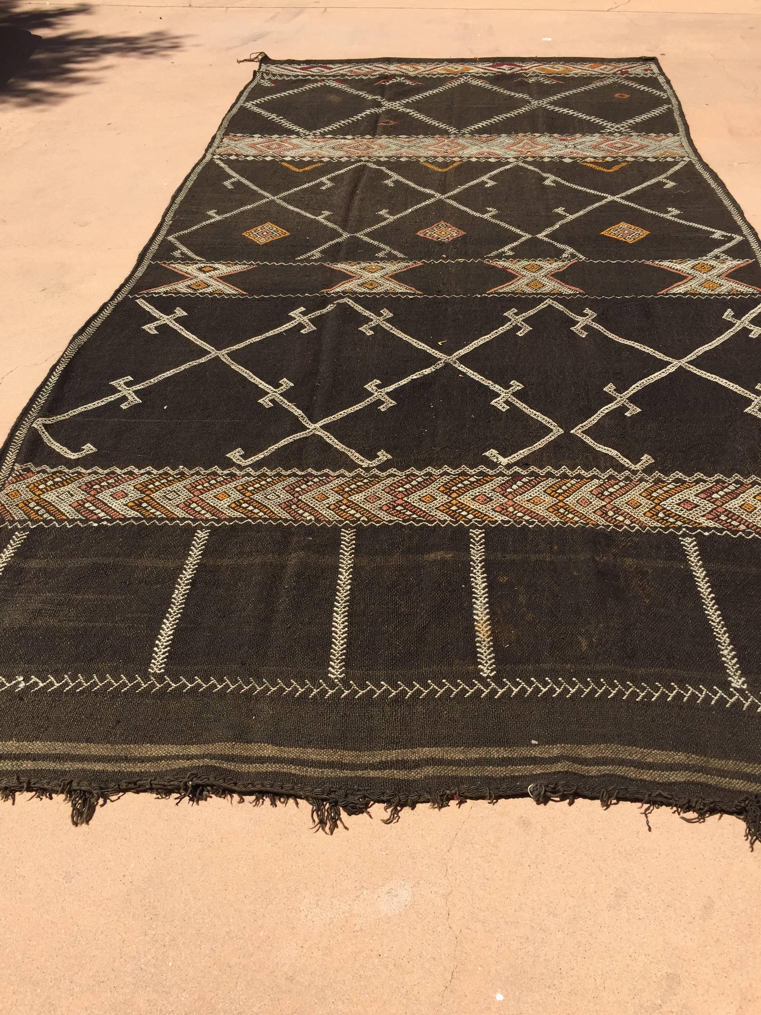 Vintage Moroccan African Nomadic Tribal rug.
Vintage Mid-Century Moroccan Nomadic rug, black camel hair with wool and cotton embroidered geometrical modernist designs in white and red colors.
Flat-weave Kilim, hand woven by the Berber women of
