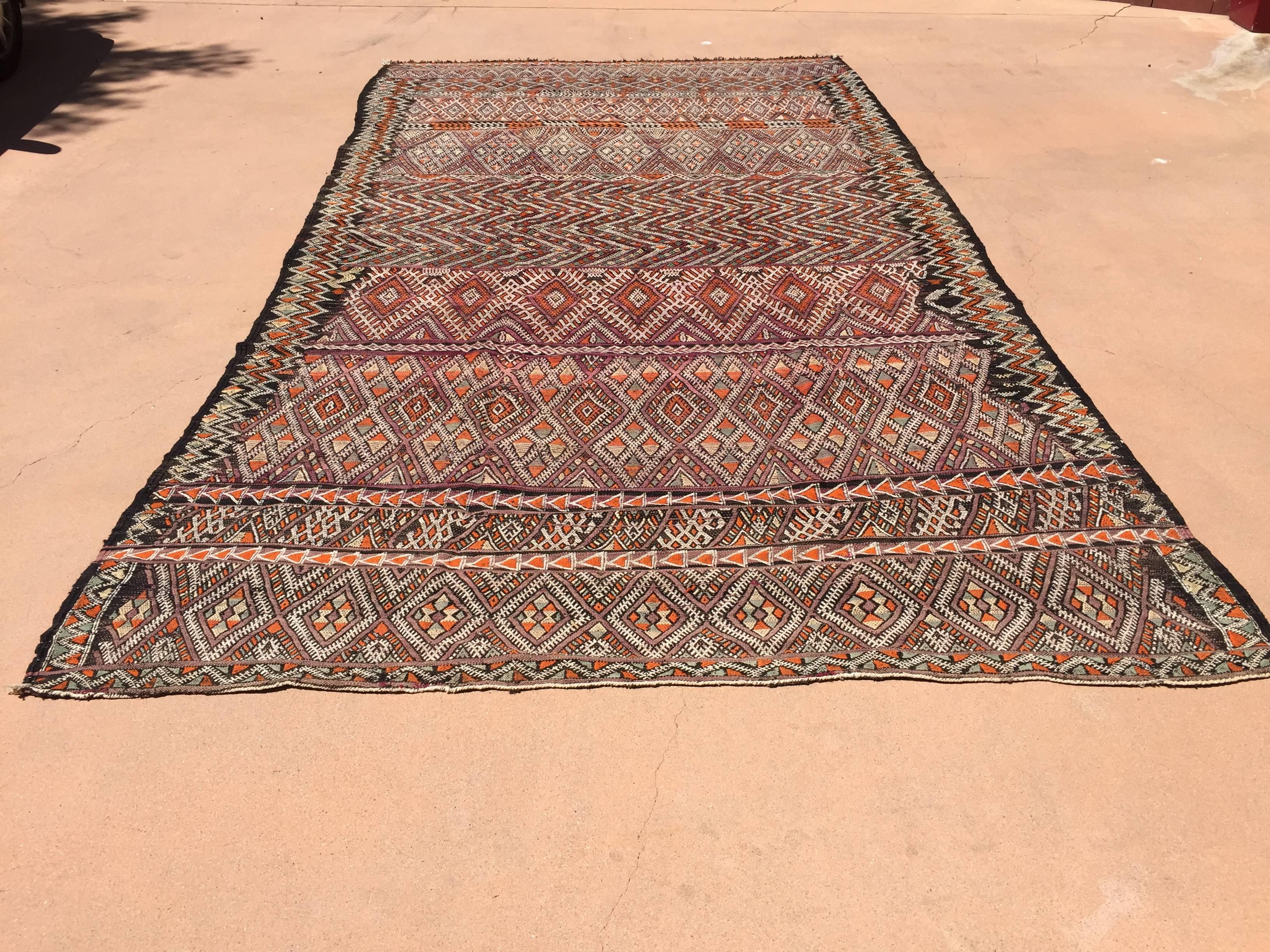 Vintage Moroccan Nomadic tribal African rug, black camel hair with wool and cotton embroidered geometrical Modernist designs in white, red and oranges colors.
Handwoven by the Berber women in Morocco.
This rug was used for room separation in the