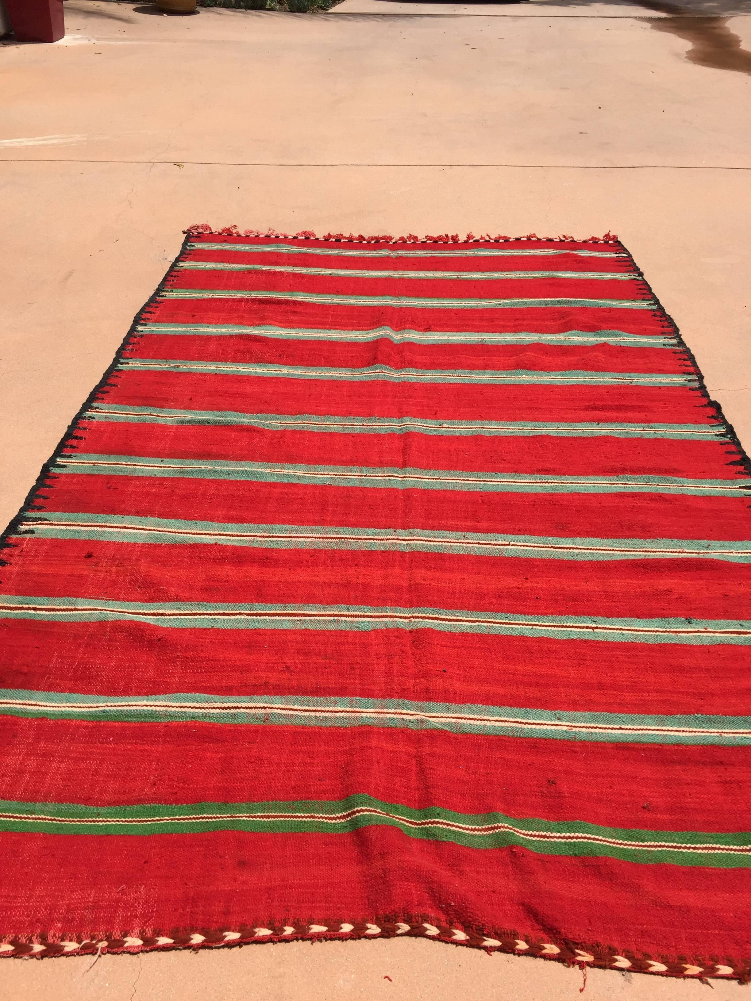 Vintage Moroccan flat-weave Kilim rug.
Large size blanket vintage Moroccan rug, handwoven by Berber women in Morocco for their own use.
This rug was made using flat-weave technique with linear pattern of alternating stripes in different colors in