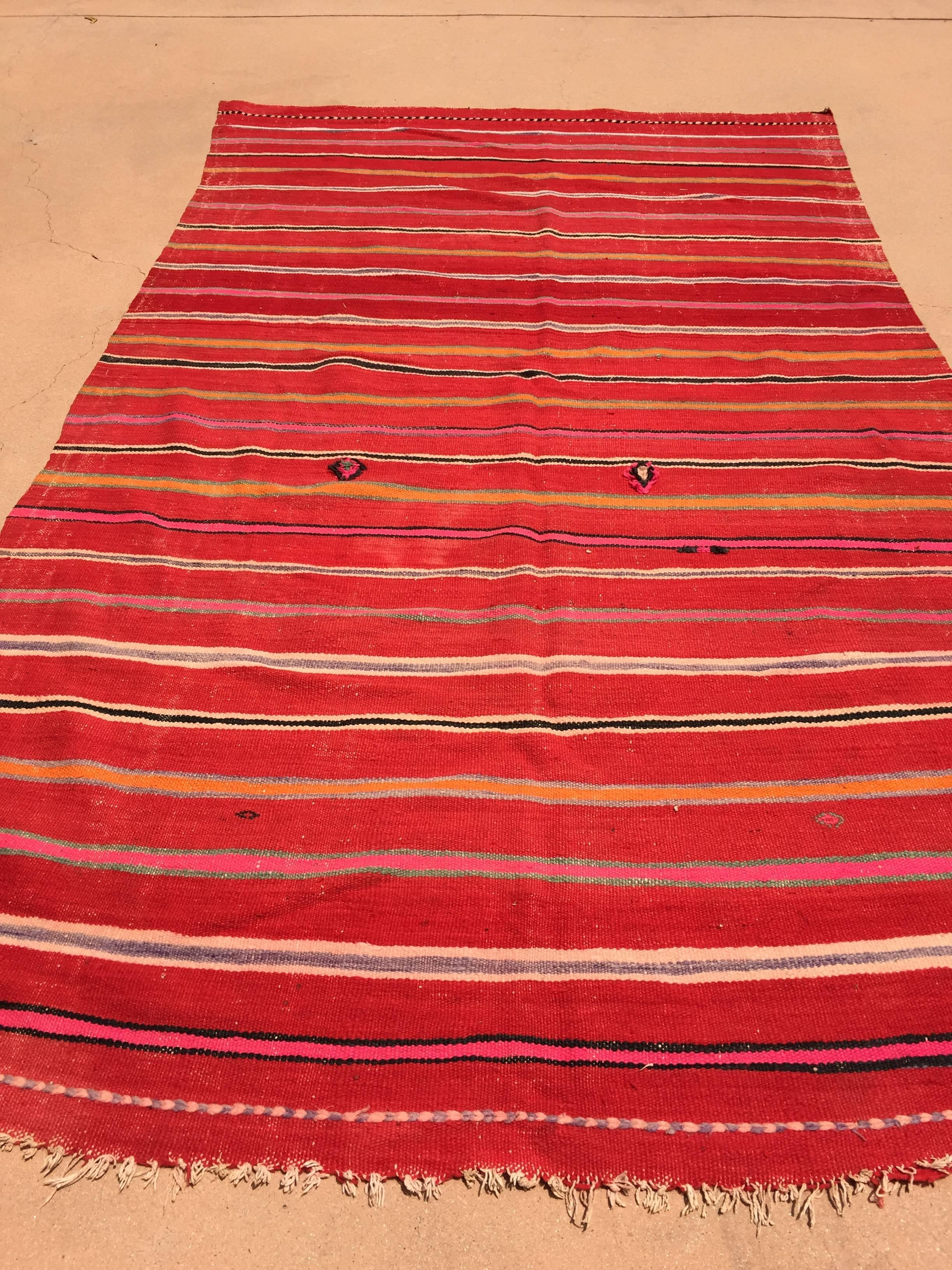 Vintage Moroccan flat-weave Kilim rug.Large size blanket vintage Moroccan rug, handwoven by Berber women in Morocco for their own use.This rug was made using flat-weave technique with linear pattern of alternating stripes in different cors in dark