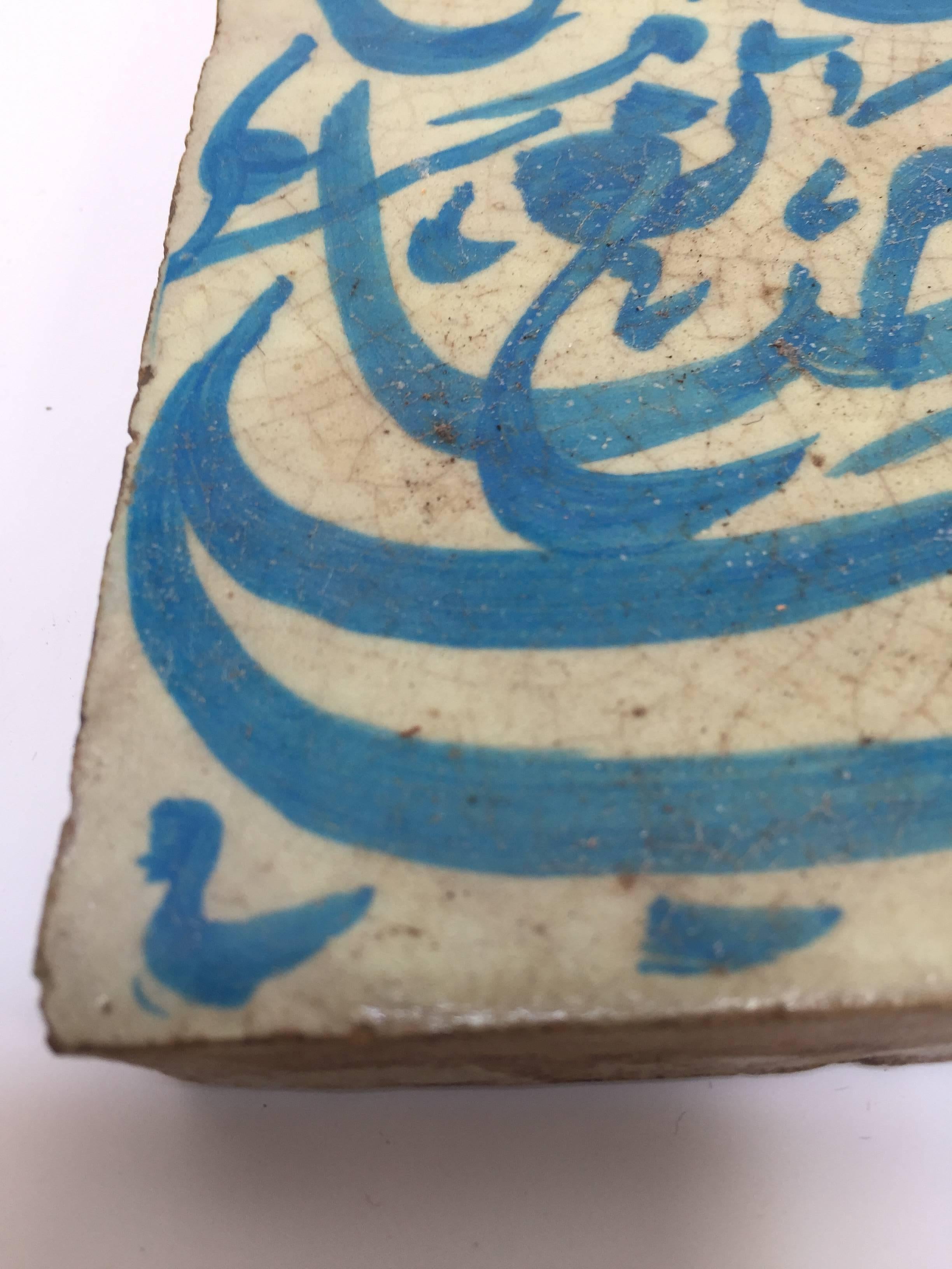 Moroccan handcrafted decorative tile with Arabic writing in turquoise blue on ivory crackle glazed ceramic.
Arabic poetry words on ceramic tile hand-painted by artist in Fez Morocco.
Great decorative Moorish artwork.
Tile is 5.75